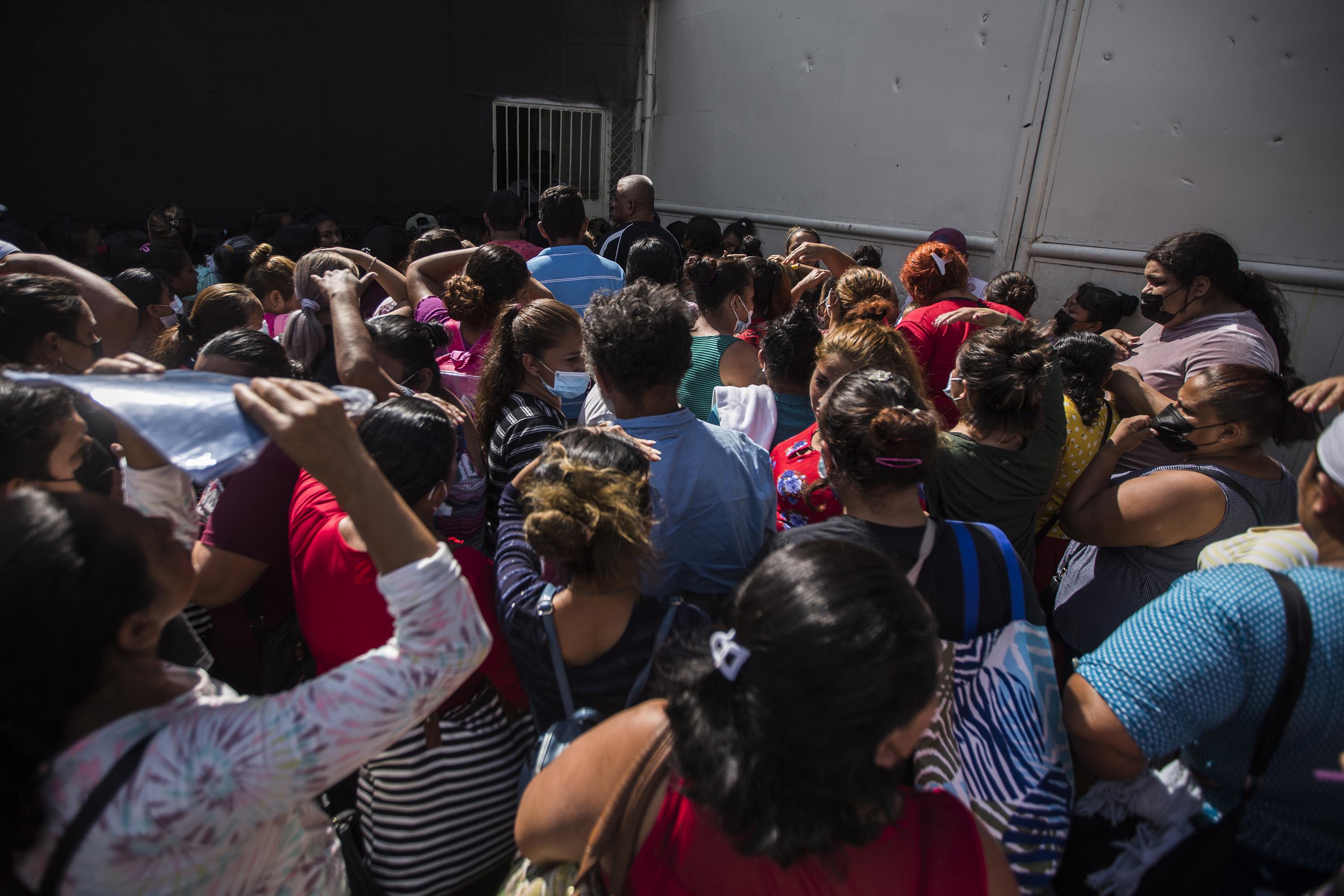 “Les voy a dar información, pero me hacen el favor de desalojar”, exigía un custodio a quienes se acumularon frente al portón de la cárcel de Mariona. “Yo les recomiendo que vengan dentro de 15 días a preguntar. Ustedes me pueden dar el nombre, pero eso no significa que les voy a resolver. Son miles de internos. Mi recomendación es que esperen y que tengan paciencia”. Foto de El Faro: Víctor Peña. 