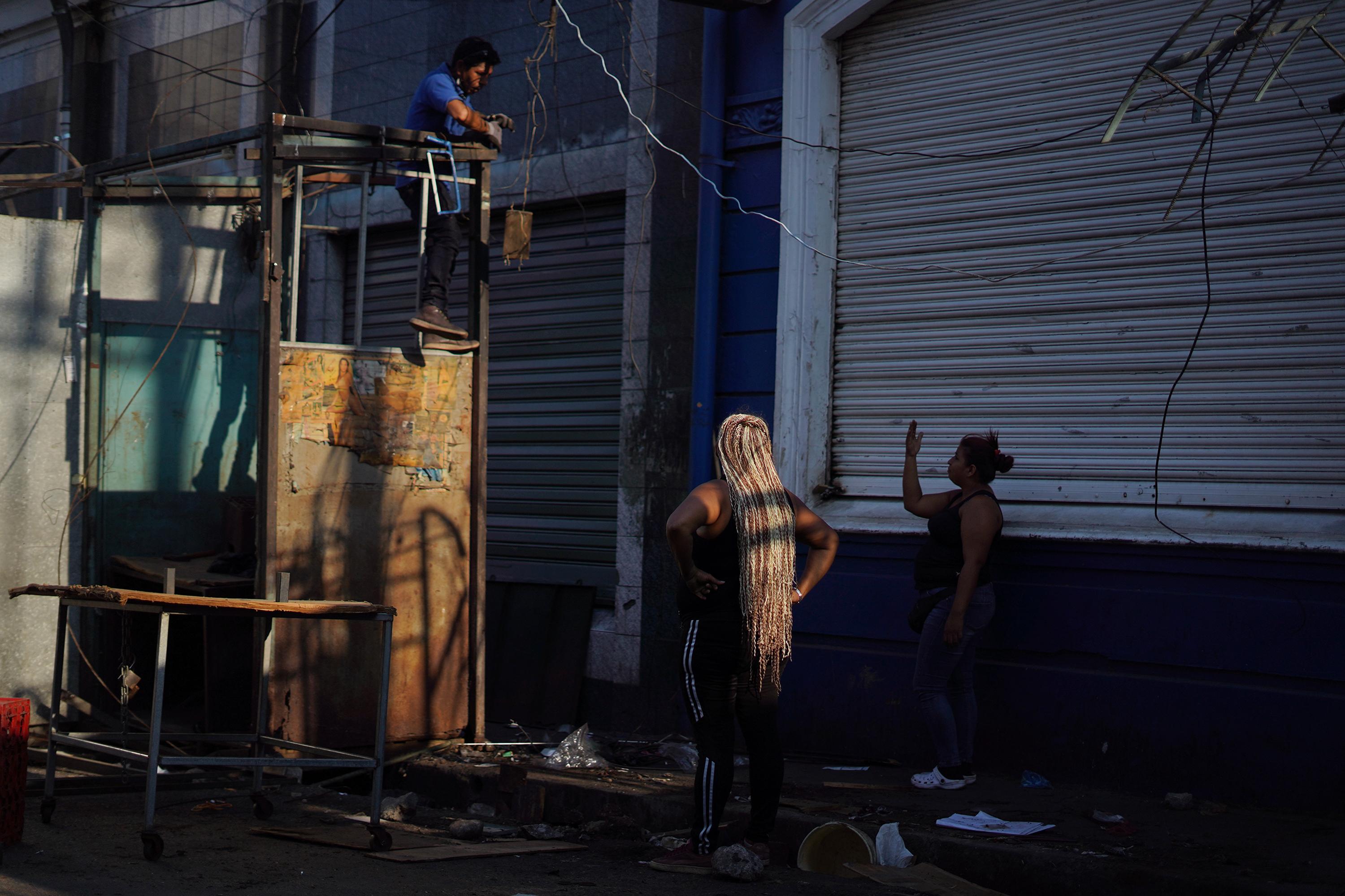 Vendedores desmontan sus locales ubicados sobre la calle Rubén Darío, en San Salvador, después de un plazo 48 horas que la Alacaldía de San Salvador dio para desalojar ese corredor de ventas, donde algunos comerciantes aseguran que cada semana pagaban $40 a la pandilla para poder vender. Foto de El Faro: Víctor Peña. 