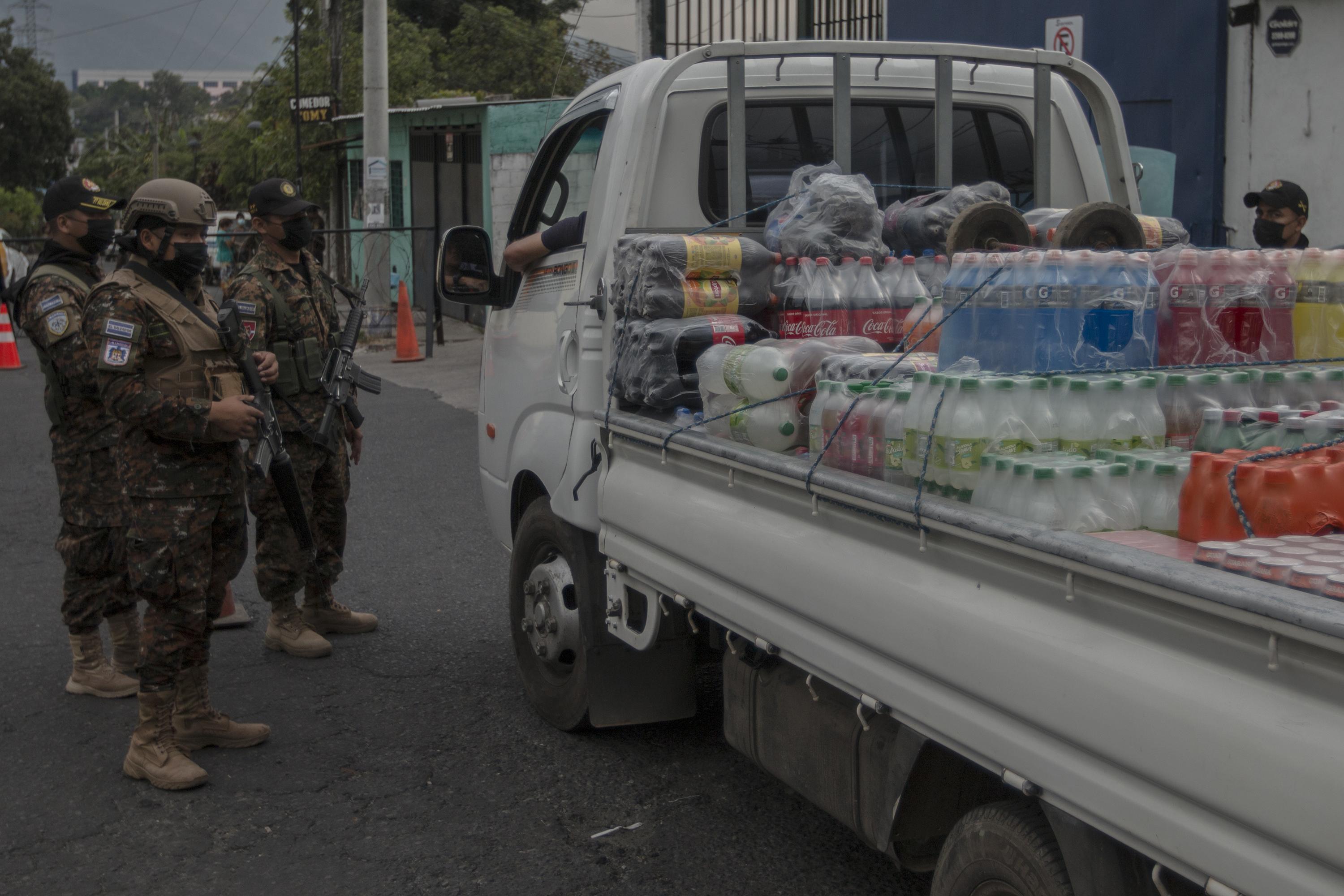 Militares revisan un camión repartidor de bebidas, sobre la entrada de la comunidad San José del Pino, en el municipio de Santa Tecla, durante el Régimen de Excepción que mantiene un operativo permanente en ese lugar. Foto de El Faro: Víctor Peña. 