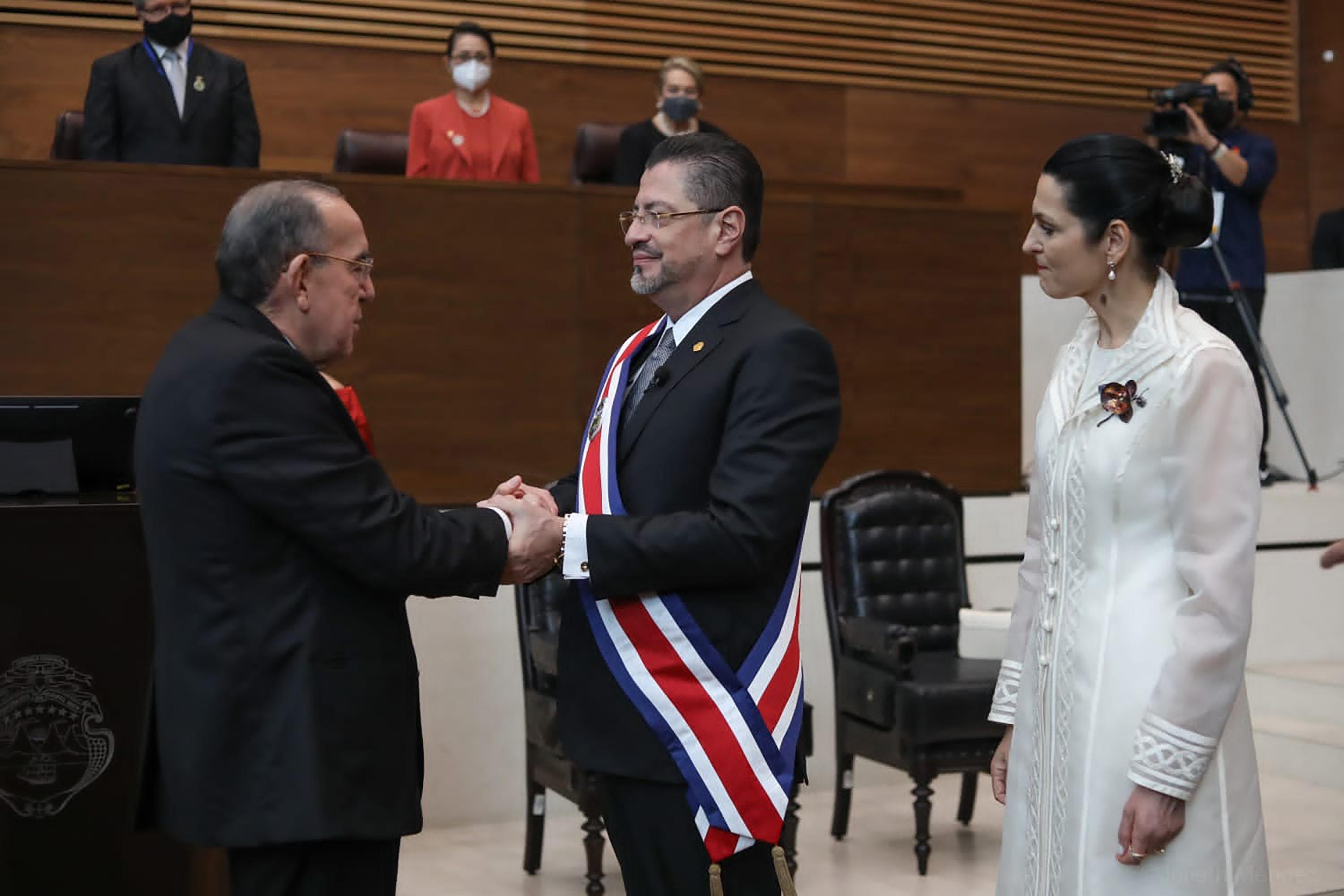 El presidente Rodrigo Chaves recibe la banda presidencial durante la toma de posesión presidida por el presidente de la Asamblea Legislativa Rodrigo Arias este domingo. Foto de El Faro: Presidencia de Costa Rica