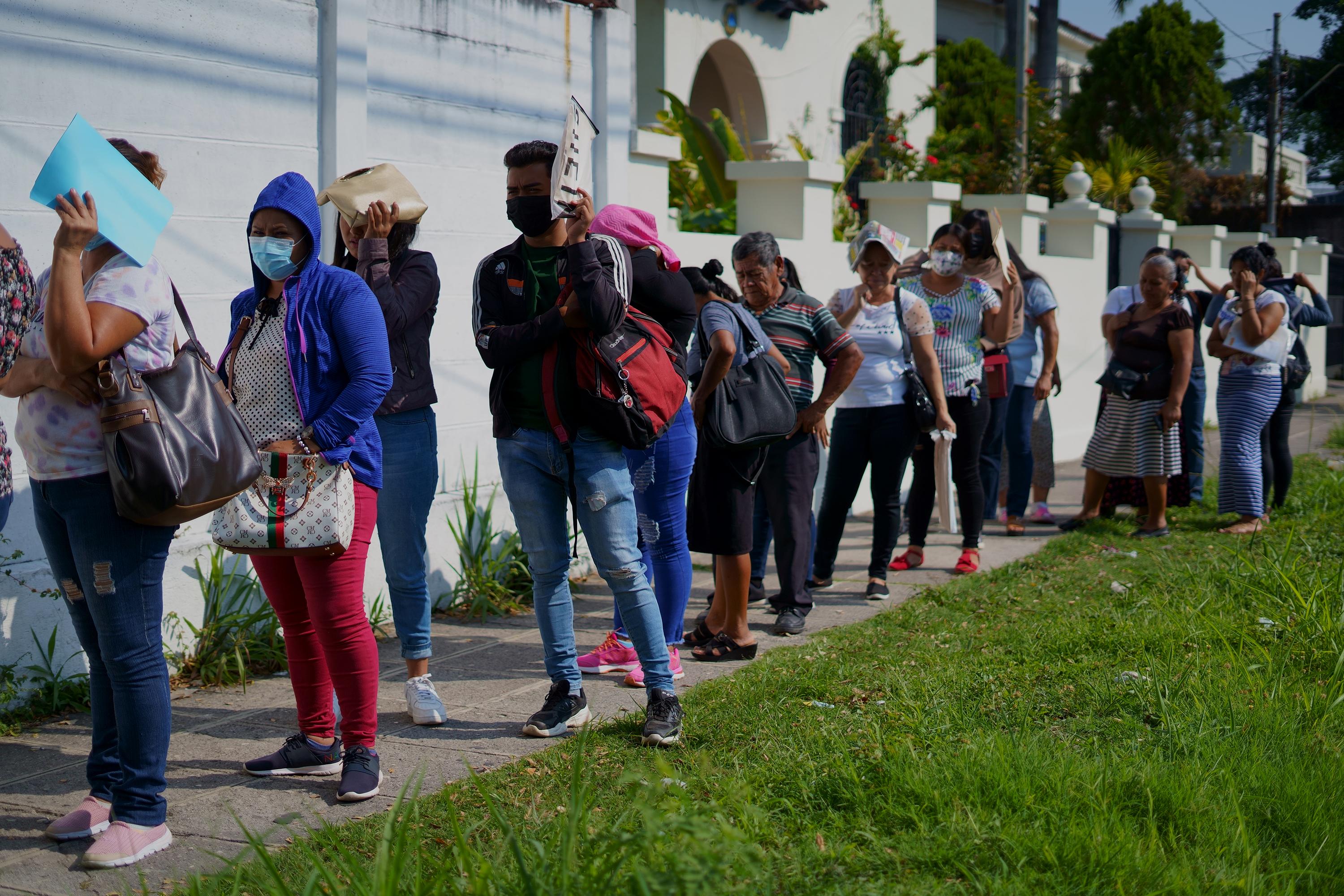 Familiares de detenidos durante el Régimen de Excepción esperan a un costado de la Procuraduría General de la República de San Salvador para acceder a un defensor público, el 25 de abril de 2022. Llegaron desde distintos municipios del país para obtener información de sus parientes. Foto de El Faro: Víctor Peña. 