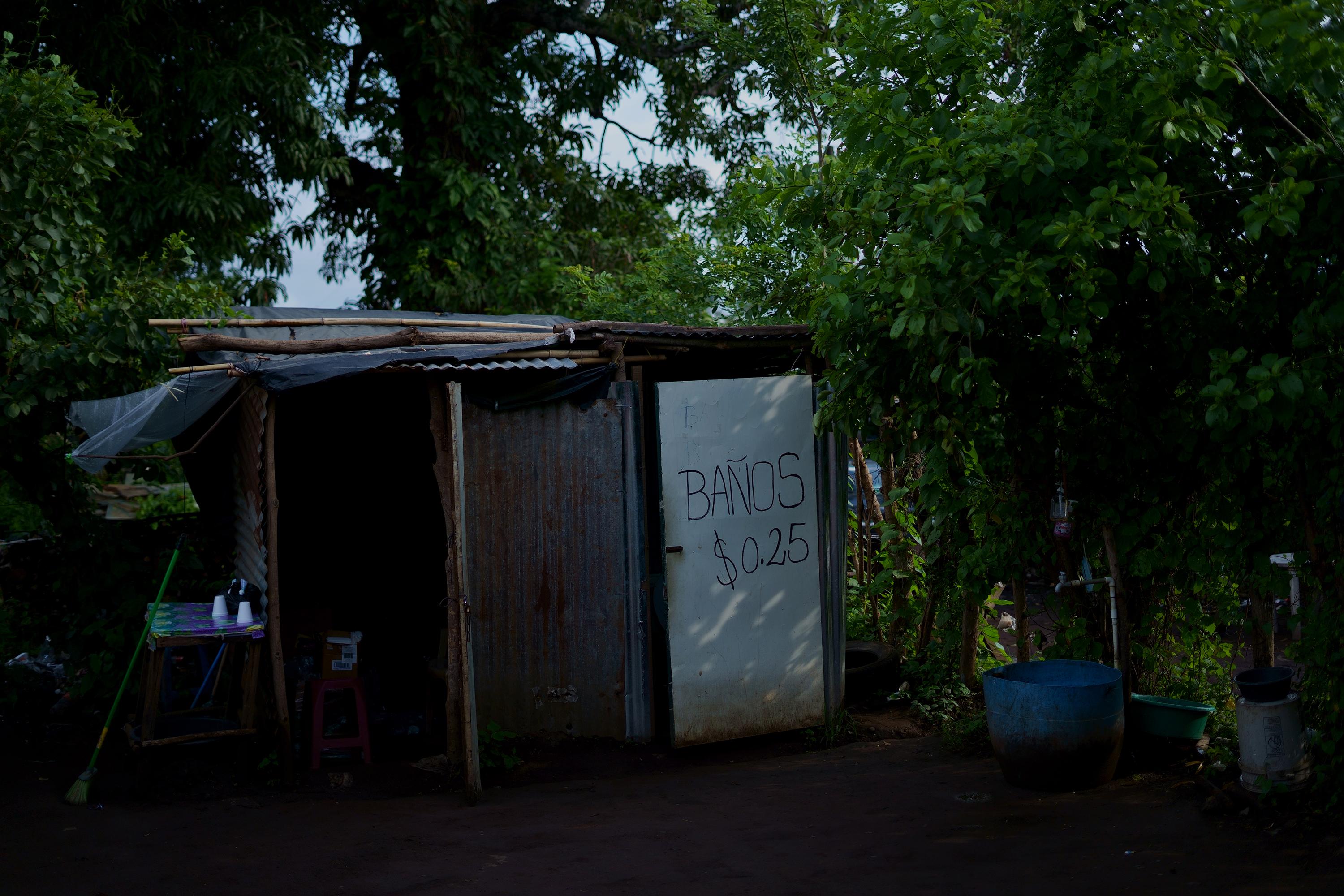 La mayoría de viviendas han puesto sus baños en alquiler para los familiares de detenidos en el Centro Penal de Izalco. Algunos habilitaron sus terrenos desocupados, como este, donde improvisaron una letrina y abrieron un parqueo que cobra $2.00 por vehículo y $025 por el uso de letrina desde que inició el Régimen de Excepción.