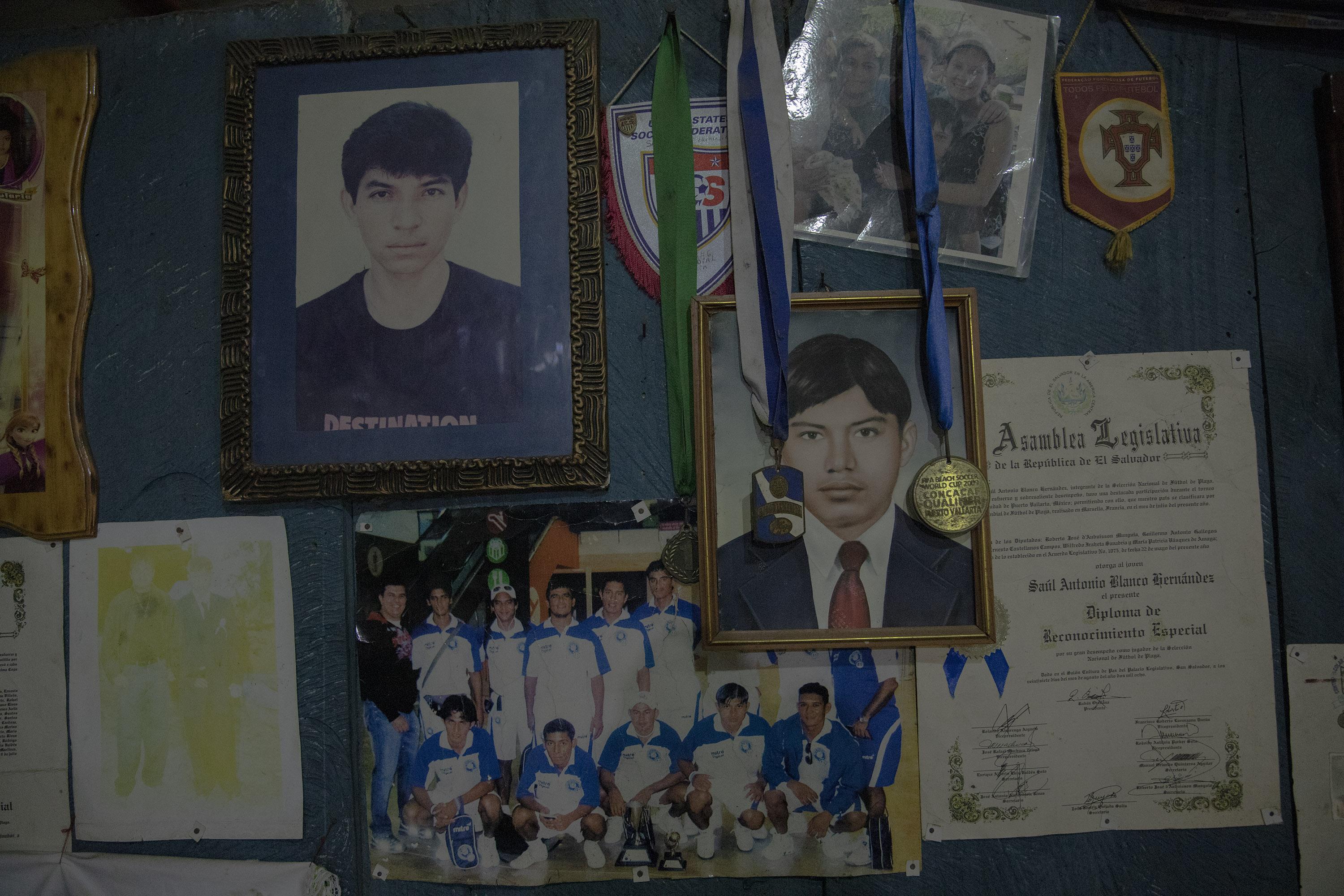 Dos banderines de las selecciones de Portugal y Estados Unidos, un reconocimiento emitido por la Asamblea Legislativa, un gafete de identificación del mundial de fútbol playa Dubai 2009 y la fotografía de la selección mundialista cuelgan de una pared de la casa del exseleccionado Saúl Antonio Blanco, quien fue detenido durante el Régimen de Excepción en la comunidad El Jobal. Foto de El Faro: Carlos Barrera