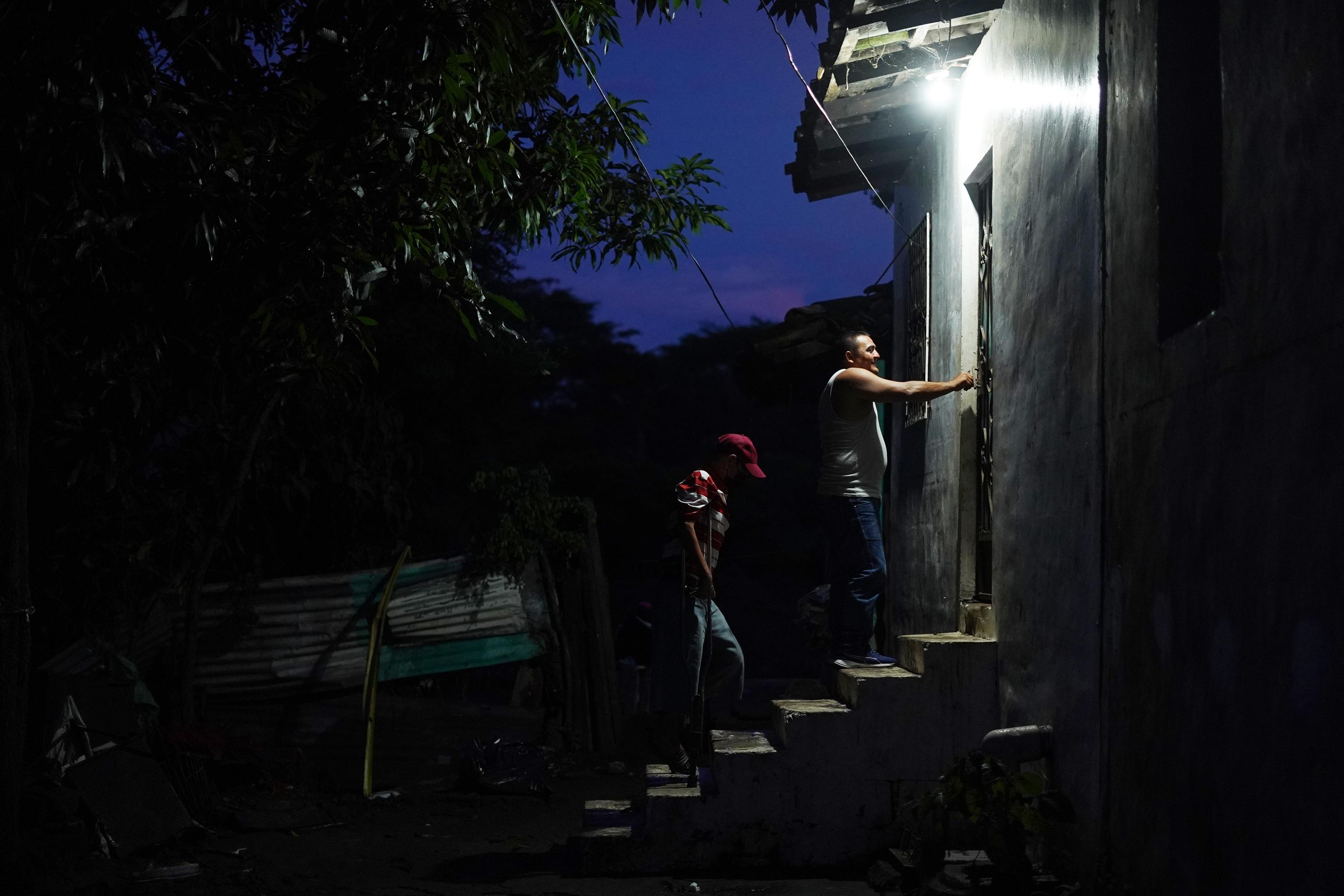 José Alberto Contreras, de 57 años, intenta subir hasta su vivienda que se inundó durante la tormenta. El río le arrastró sus muletas y ahora se apoya con un par que sus amigos de la comunidad armaron con pedazos de hierro y palos. Sus vecinos lo sacaron cargado entre el agua y los escombros la madrugada del lunes 10 de octubre.  Su casa está a solo 20 metros de la orilla del río. José quedó con discapacidad para caminar después de un accidente de vehículo a sus 18 años. Vive con su hijo de 12 años y sobrevive con la ayuda que recibe de su hermana.