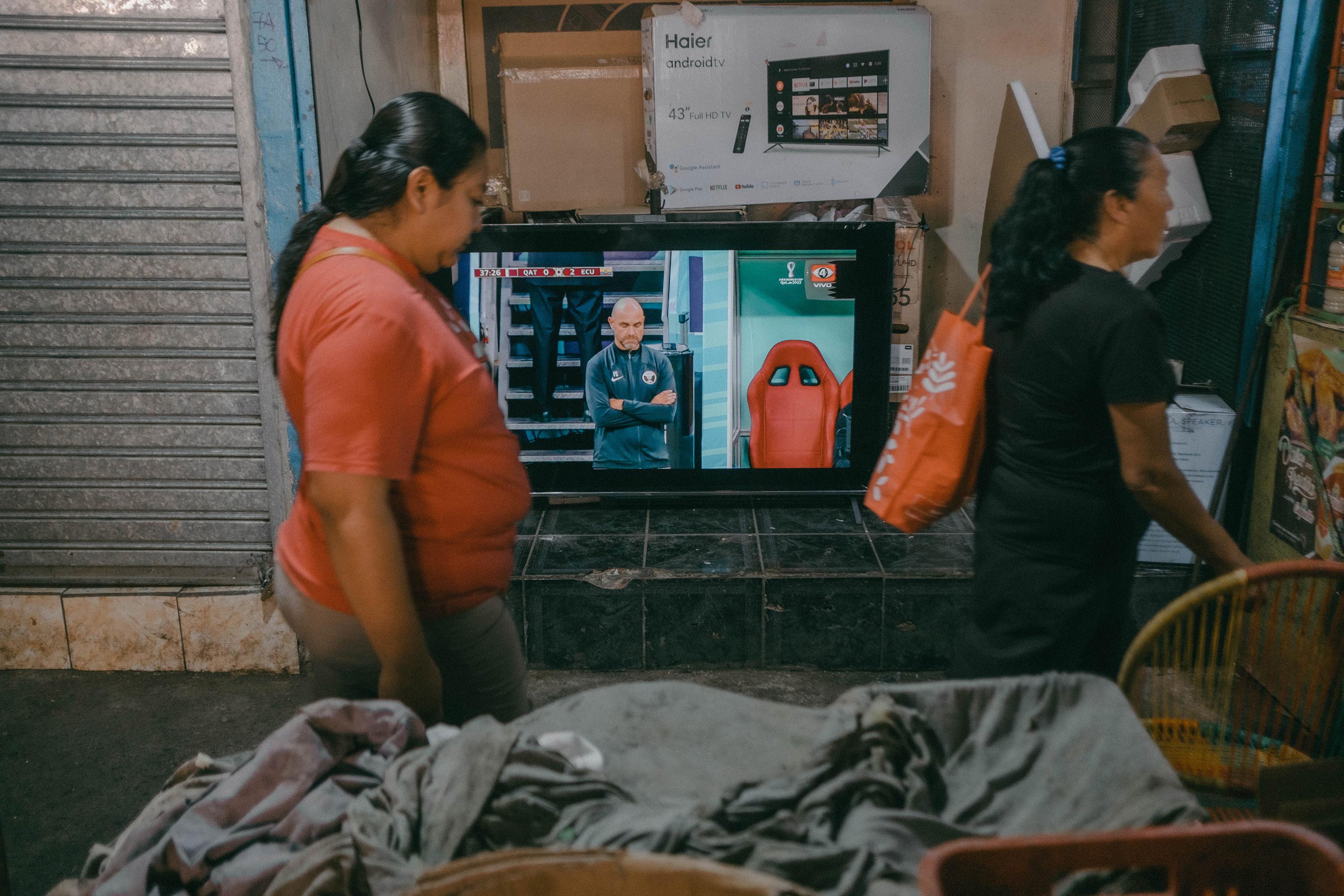 El inicio del mundial Qatar 2022 pasó inadvertido en la zona del Mercado Central, San Salvador. En uno de los pasillos, en una pantalla de 55 pulgadas setransmitía el partido entre el equipo qatarí y Ecuador con resultado de 0-2 a favor de los sudamericanos, en el lugar nadie se detenía a observar siquiera un minuto del encuentro. Foto de El Faro: Carlos Barrera