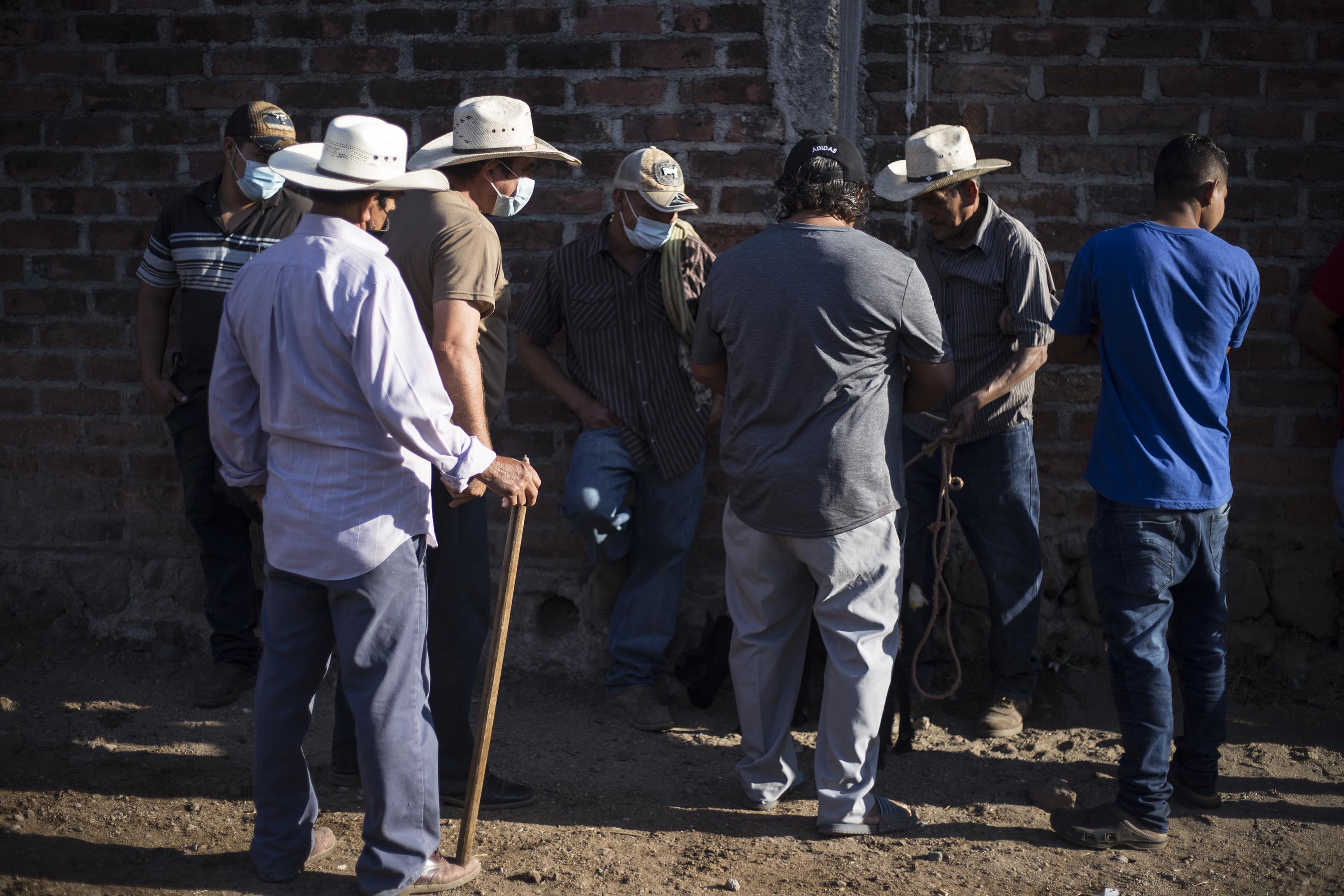 Ganaderos conversan durante el tiangue, el mercado agrícola que se realiza cada jueves en el municipio de Aguilares, San Salvador. Solo dos de cada 10 salvadoreños tienen acceso a una pensión. Foto de El Faro: Víctor Peña. 