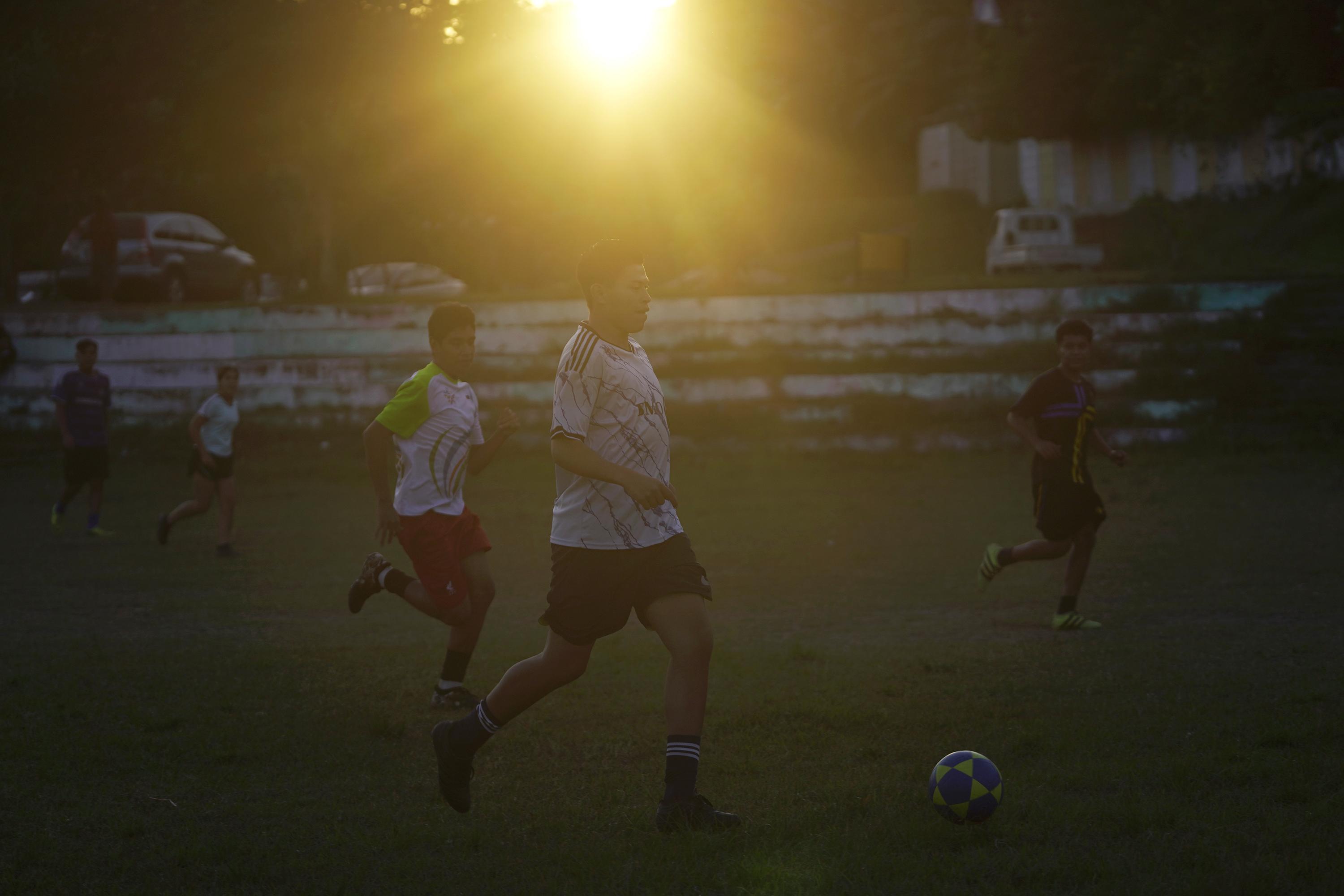 Habitantes de la quinta etapa de Las Margaritas, en Soyapango, juegan en la cancha de fútbol. Esta era una frontera con la comunidad Las Vegas, donde solía haber enfrentamientos entre la MS-13 y el Barrio 18 Sureños. Desde hace algunos meses, familias enteras llegan a este sitio y todos los días hay un partido de fútbol a partir de las 5:00 de la tarde. Foto de El Faro: Víctor Peña.