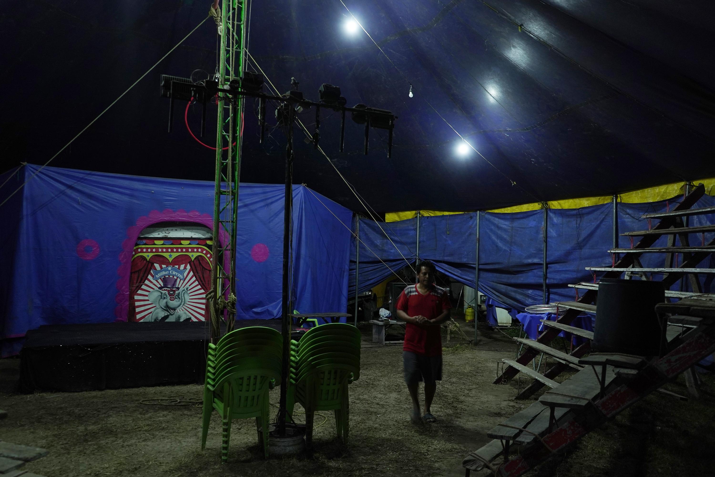 Rigoberto, de 53 años, prepara el escenario para la función. Es empleado del circo Majestic, que se instaló en la urbanización Las Margaritas, en Soyapango. Algunas veces pagaron hasta $300 por instalarse en un lugar controlado por pandillas. “Legalmente ellos eran la autoridad. Ahora las cosas han cambiado y ya no se trabaja con ese temor”, dice Rigoberto. El circo no ha pagado extorsión esta vez. Foto de El Faro: Víctor Peña.