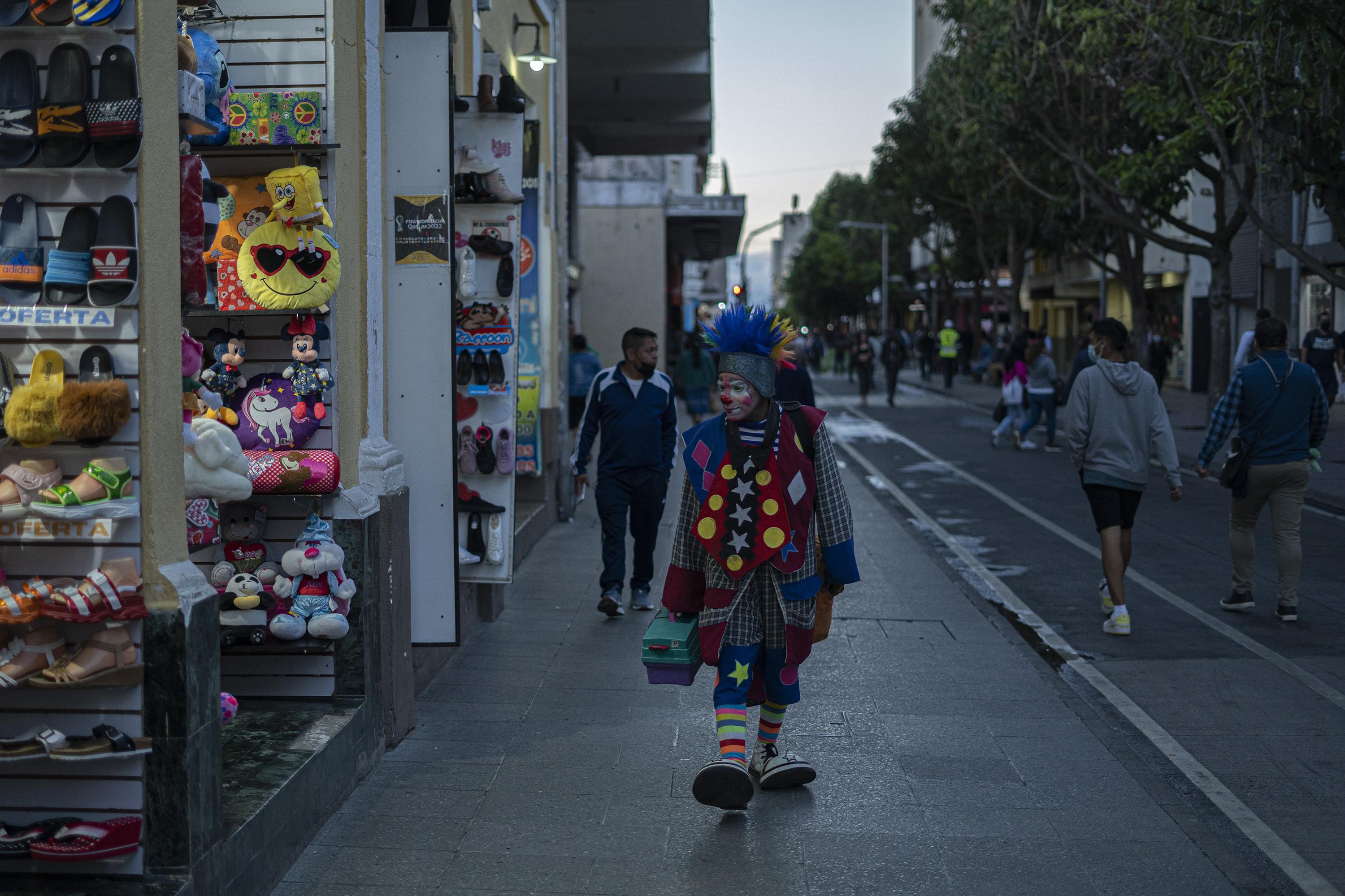 La Sexta avenida es espacio de sobrevivencia para los migrantes atascados en Guatemala. El payaso Zancudito, de origen salvadoreño, lleva más de 20 años recorriendo esta peatonal, donde gana alrededor de 150 quetzales (19 dólares) por día. Foto de El Faro: Víctor Peña.