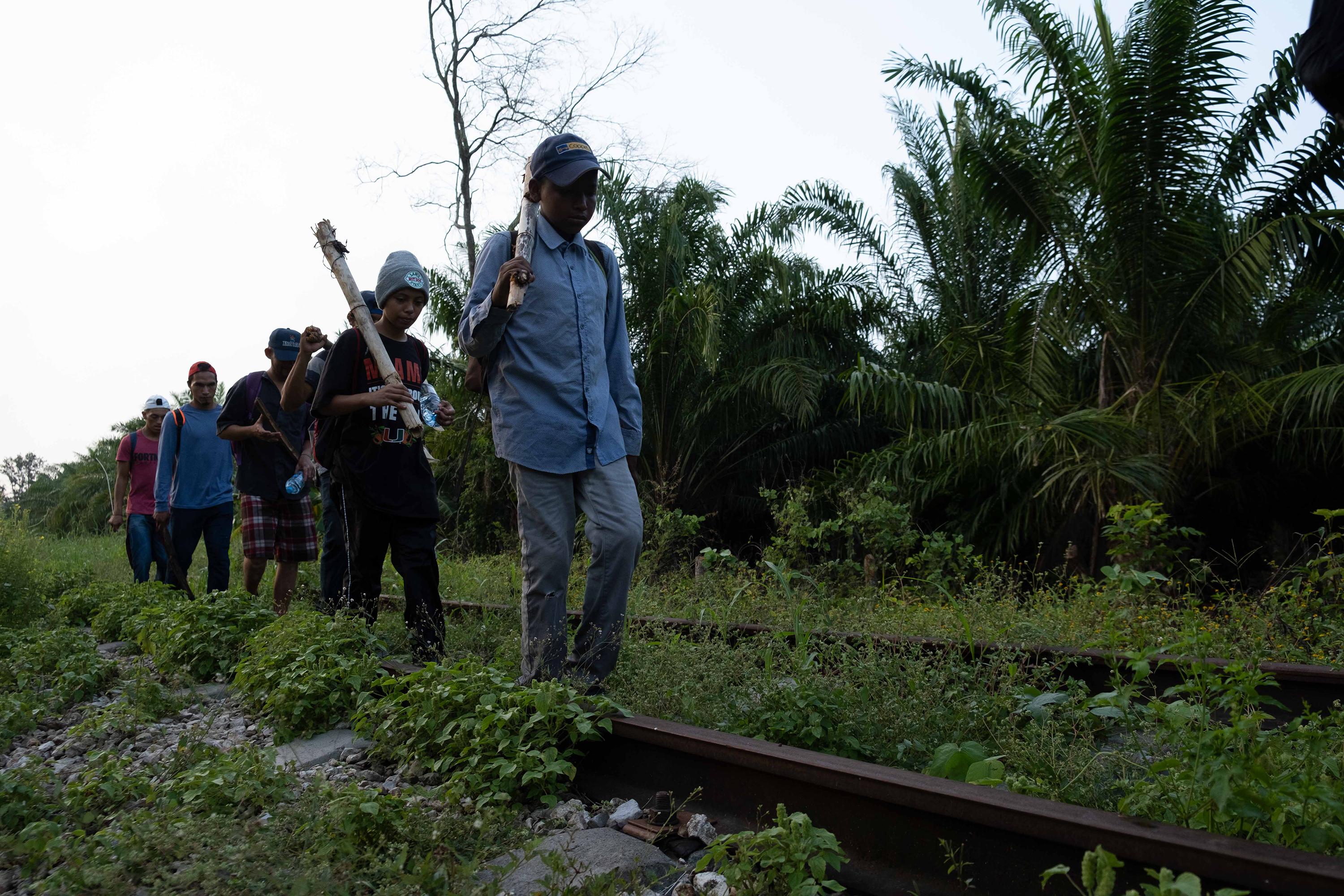 Migrantes caminan sobre las vias del tren con dirección al norte del territorio mexicano, en Palenque, Chiapas, México. La segunda en la fila es Amaya, disfrazada de muchacho. Foto de El Faro: Isabel Mateos. 