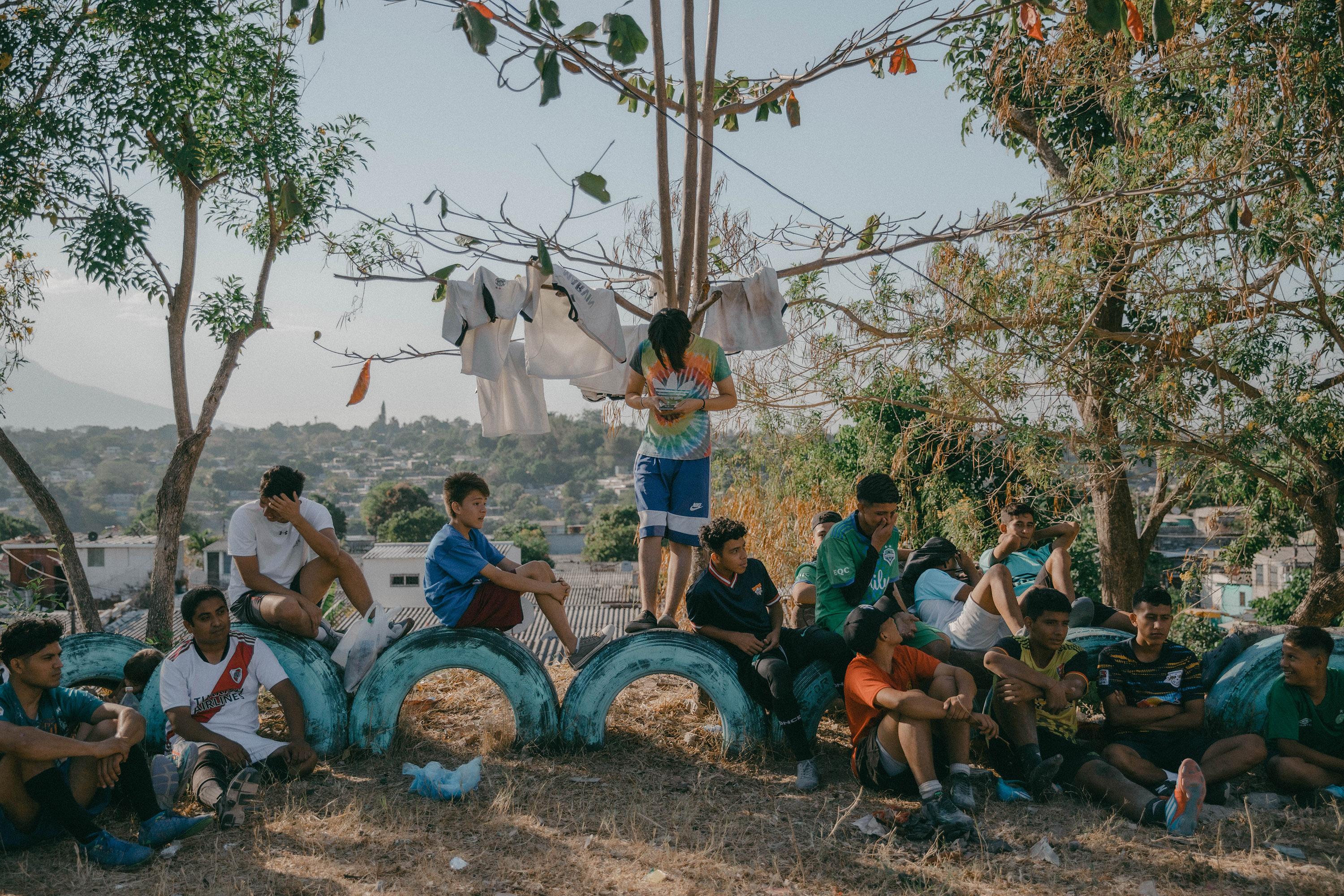 Youth from lower Las Cañas, a community that, until recently, was controlled by the Sureños faction of 18th Street, rest at halftime during a soccer match against their neighbors from upper Las Cañas, once controlled by MS-13. Photo: Carlos Barrera/El Faro