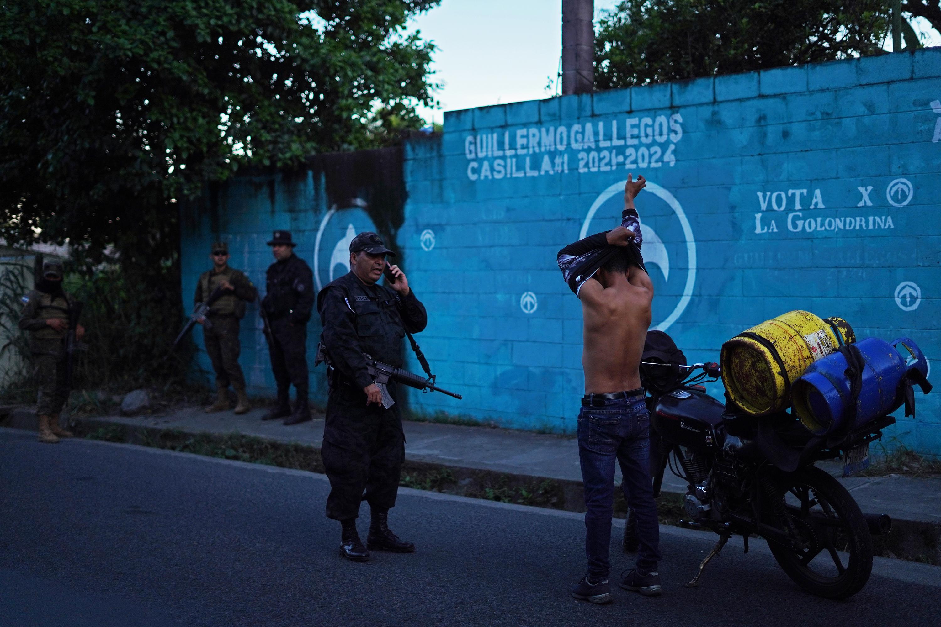 On Dec. 2, 2022, the government set up a security perimeter in the neighborhoods of Las Margaritas and Las Campaneras, considered one of the most dangerous areas in the municipality of Soyapango. Anyone found on the street was intercepted by police or military agents and checked for tattoos, as shown in this photo by Víctor Peña.