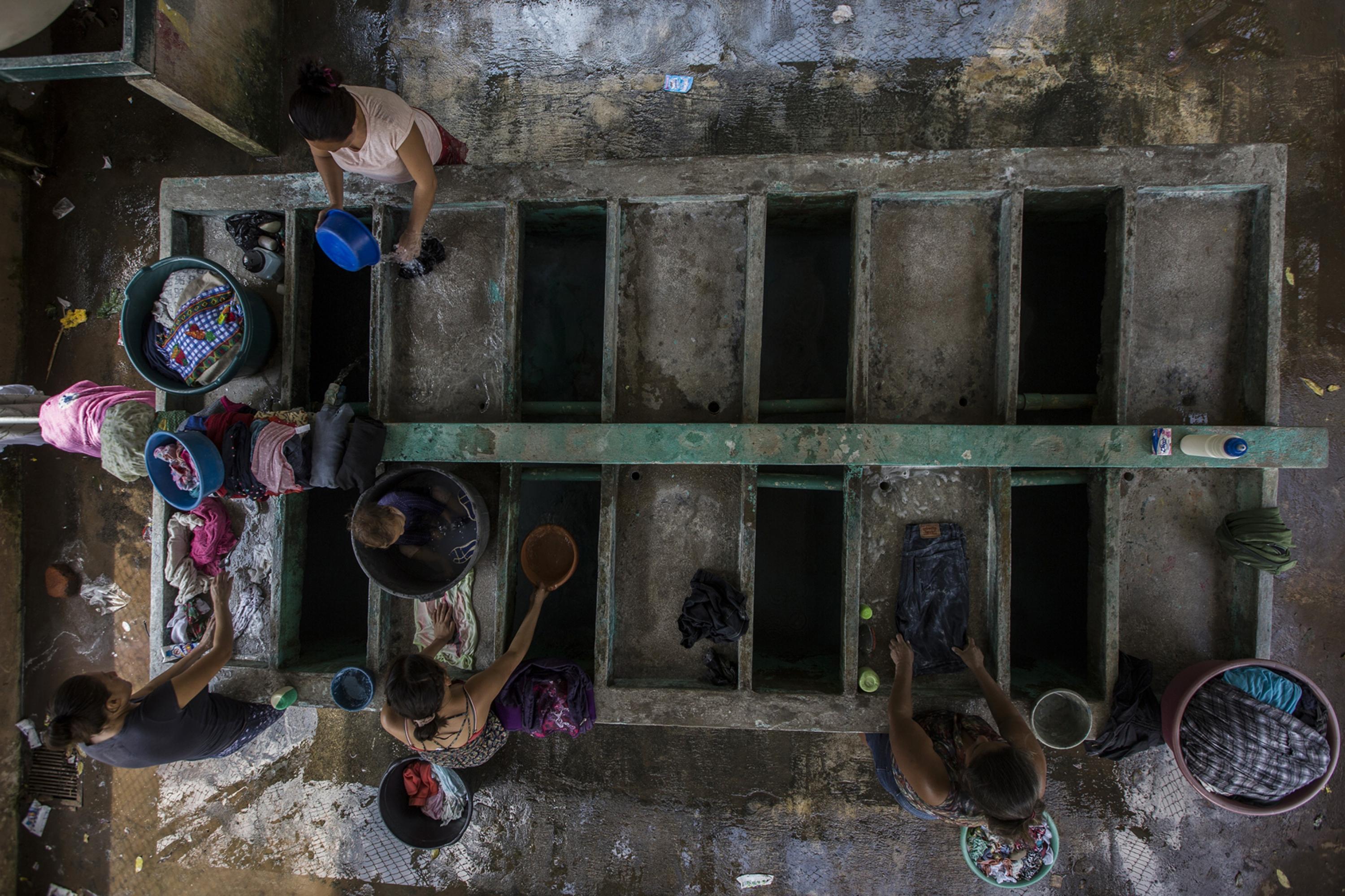 Every morning, women travel to communal washing places with their clothes and children. Sundays are especially busy. They start arriving at 4 a.m. to guarantee a space and take advantage of the basins full of water. Some men meet them mid-morning to carry the clothing back home.