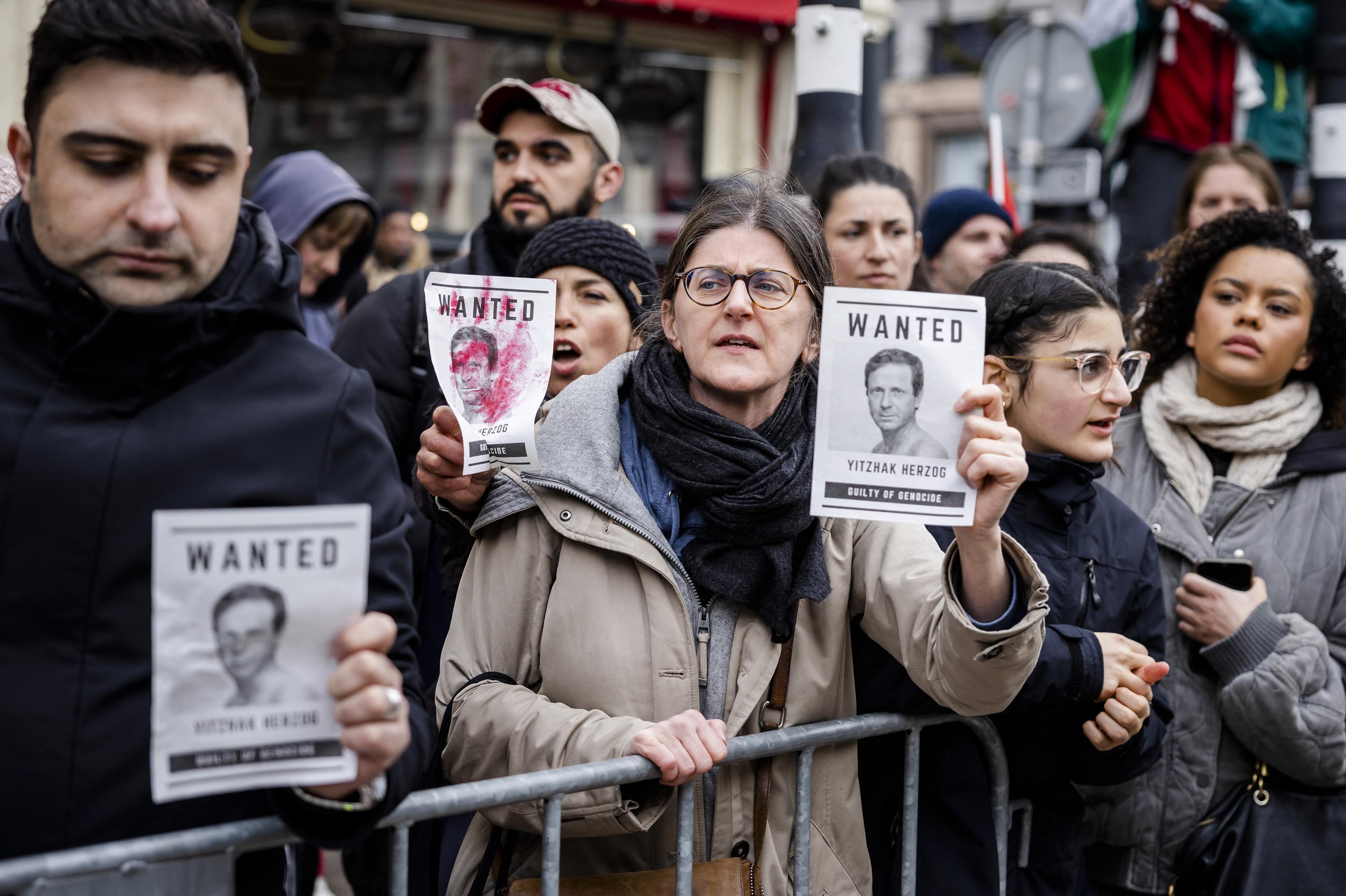 Protesters hold placards with portraits of Israeli President Isaac Herzog as they demonstrate against his presence at the opening ceremony of the National Holocaust Museum in Amsterdam, on March 10, 2024. Eighty years after World War Two, the Netherlands is poised to open its first Holocaust museum, as before the war and the Nazi occupation, the Netherlands was home to a vibrant Jewish community of around 140,000 people, mainly concentrated in Amsterdam. By the time the Holocaust was over, an estimated 75 percent —102,000 people— had been murdered. Photo Michel van Bergen/ANP/AFP/Netherlands OUT