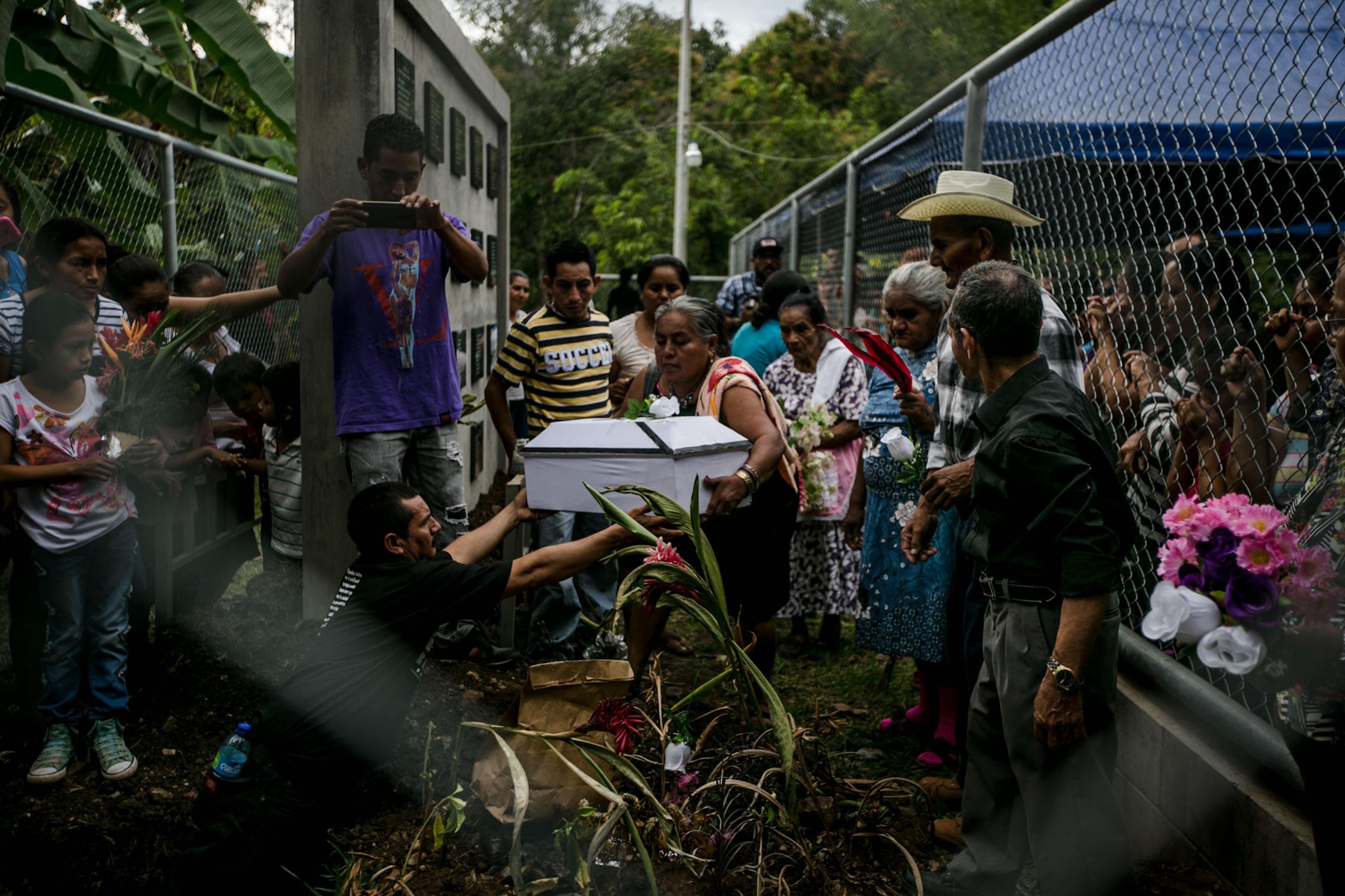 Residents of the hamlet of El Potrero in the village of La Joya bury their family members in a monument honoring the victims of the El Mozote massacre. They buried the remains of 19 people on Sunday, Dec. 11, 2016. Photo Fred Ramos