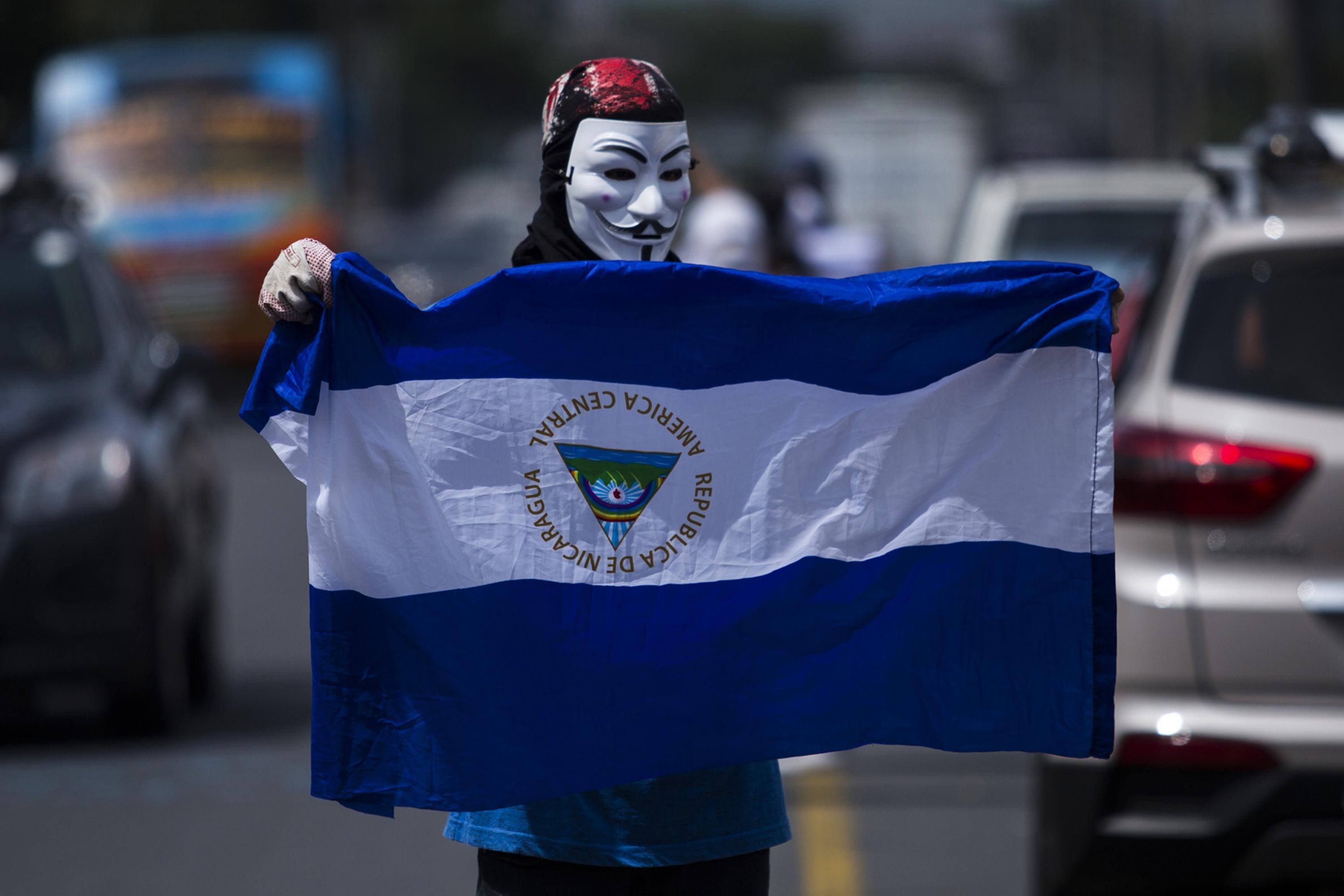 A lone student protests in front of Central American University on Monday, Oct. 1, 2018. Some 20 people attended the demonstration, surrounded by hundreds of police officers. Photo Víctor Peña