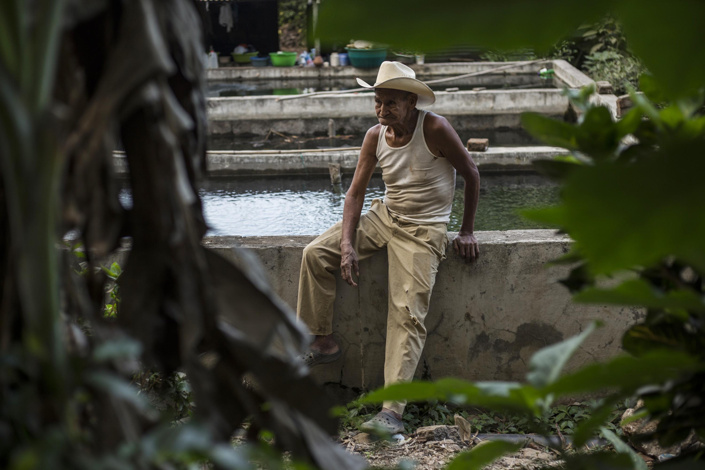 Antolino Artero, 82, helps his daughter to farm tilapia. Every three months they produce around 200 pounds for their own consumption. Another 17 families also engage in this farming, which does not produce any surplus for sale. “We enjoy the water here. If they take it away, we will be forced to buy it by the jug. We see that President Bukele is busy at work, so we ask him to pay attention to this attempted theft from the community,” he says.