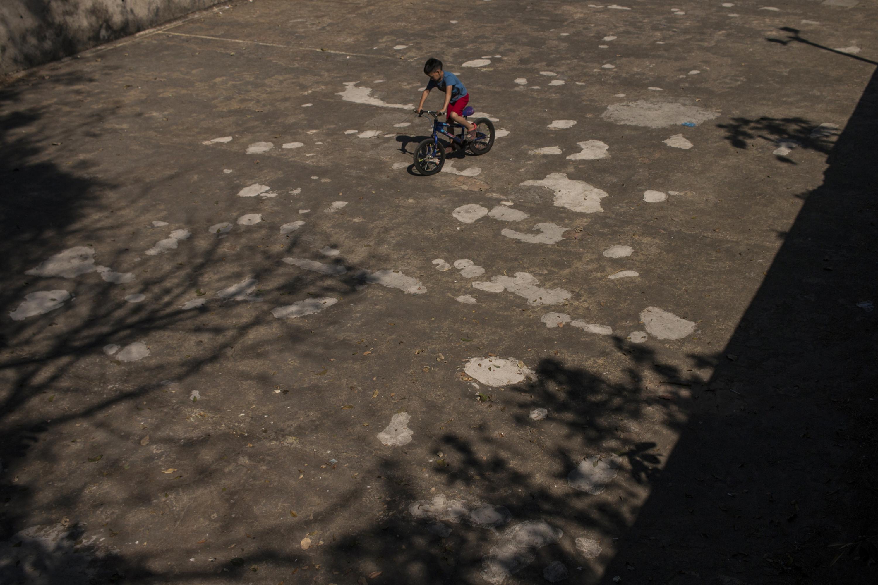 Enio Mauricio Ramírez, seven, plays in an empty water tank that La Labor Hacienda used to wash coffee. Spanning 25 by 15 meters, it used to be filled directly from the local water supply through a canal that stretched 300 meters. It was taken out of service in 2012 and now, in ruins, serves as a mini soccer field.
