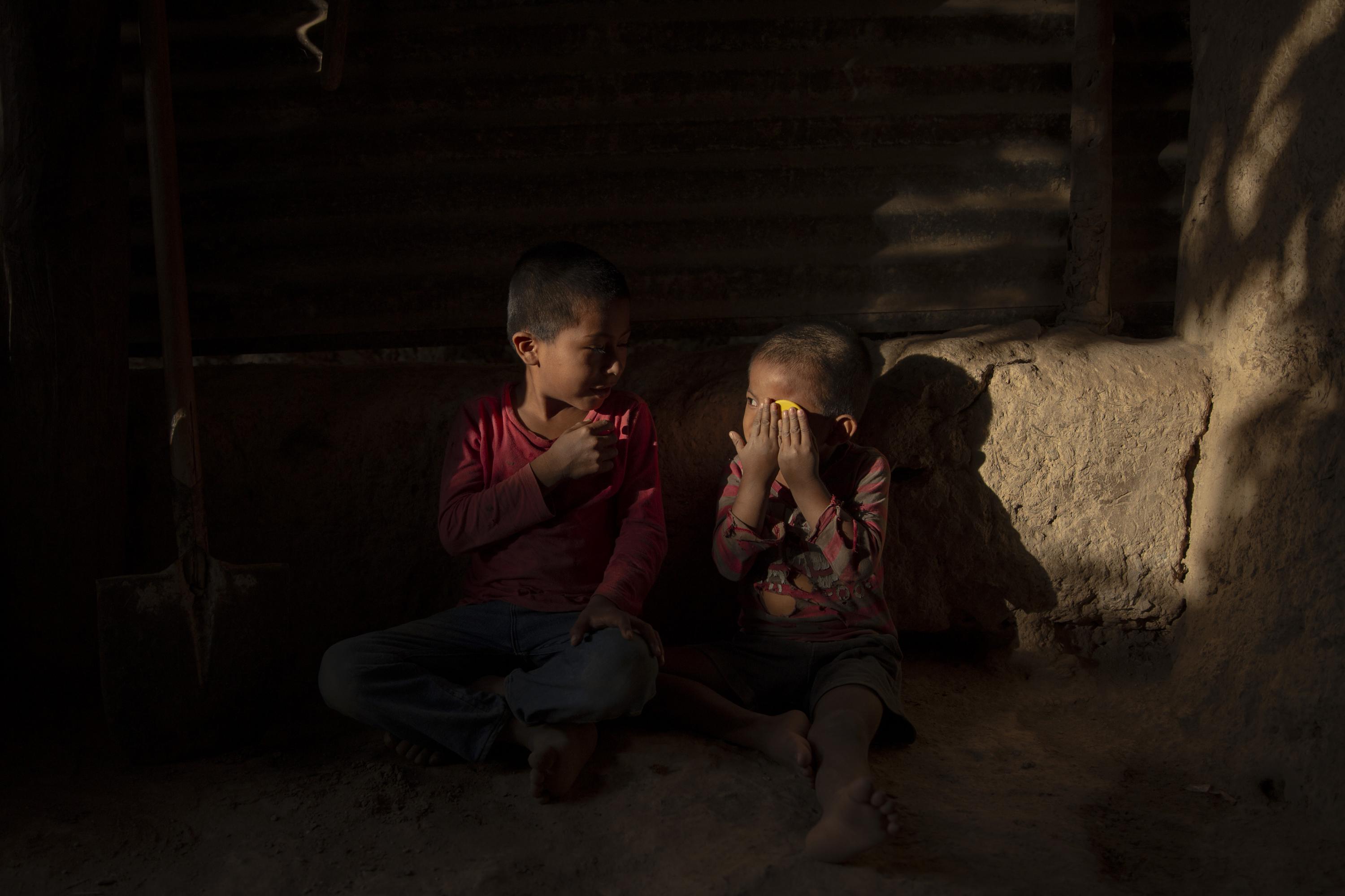 Two brothers —Santos Alfredo, seven, and Santos Adilson, four— play at home in the canton of Pitahaya in the municipality of Camotán. A total of twenty seven children live here, born of six sisters who became mothers when they were children themselves, of 13, 14 and 16 years old. The kids live crowded together in small huts distributed across their grandparents’ land. They run barefoot from one side of the yard to the other, with swollen bellies, playing in the dirt and with dogs and a litter of baby pigs that wallow in the mud. Camotán is part of Central America’s Dry Corridor, and is one of the areas most impacted by the climate crisis. Camotán also has the highest rate of chronic malnutrition and the second highest rate of acute malnutrition in the department of Chiquimula. The main causes of illness in children are gastrointestinal infections, colds, and pneumonia, all caused by malnutrition and deficiencies in the body