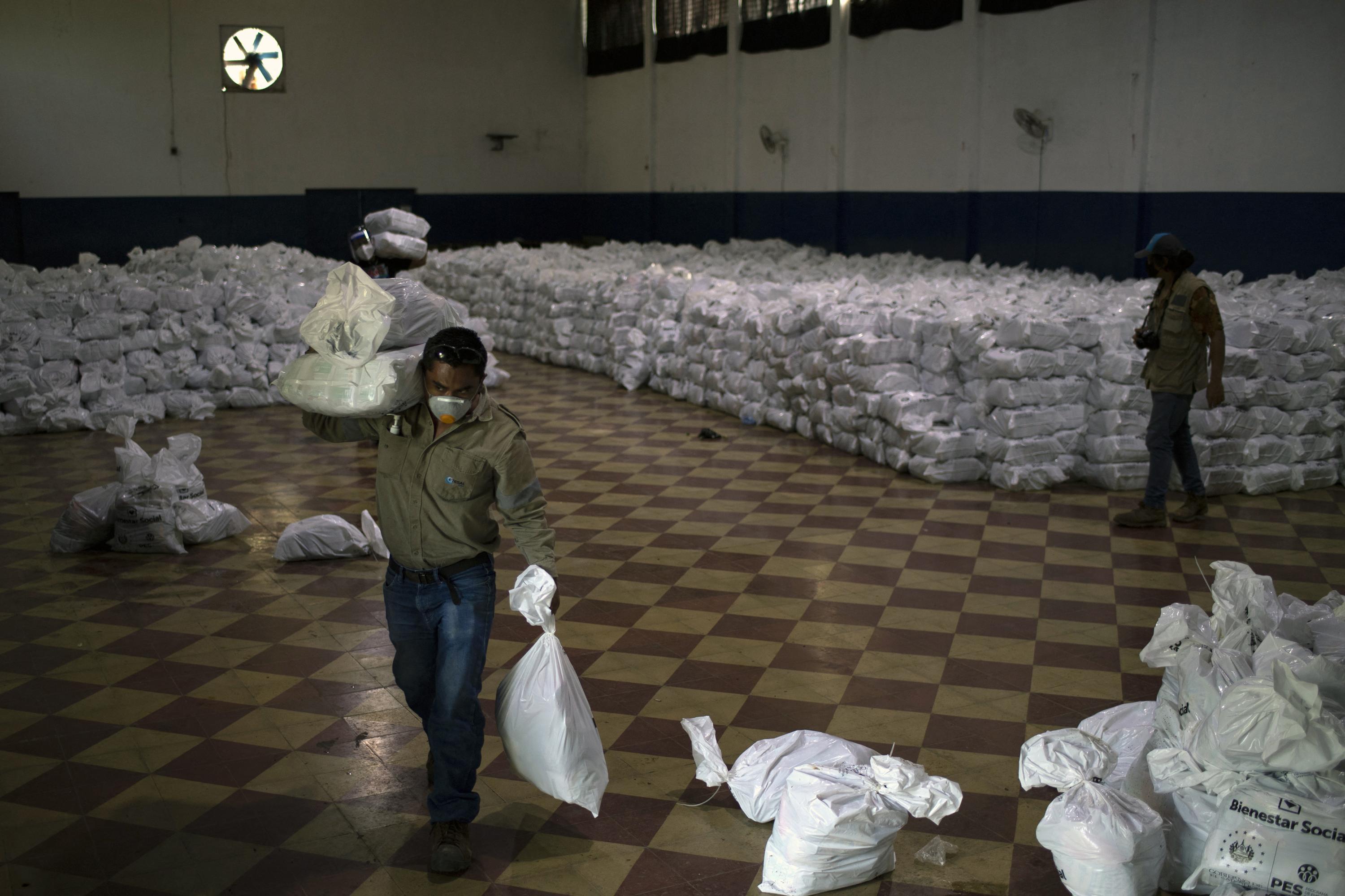 A worker of the Salvadoran Energy Transmission Company, ETESAL, loads food packages at the collection and distribution center in the city of Santa Ana, El Salvador, on July 1, 2020. Photo Yuri Cortez/AFP