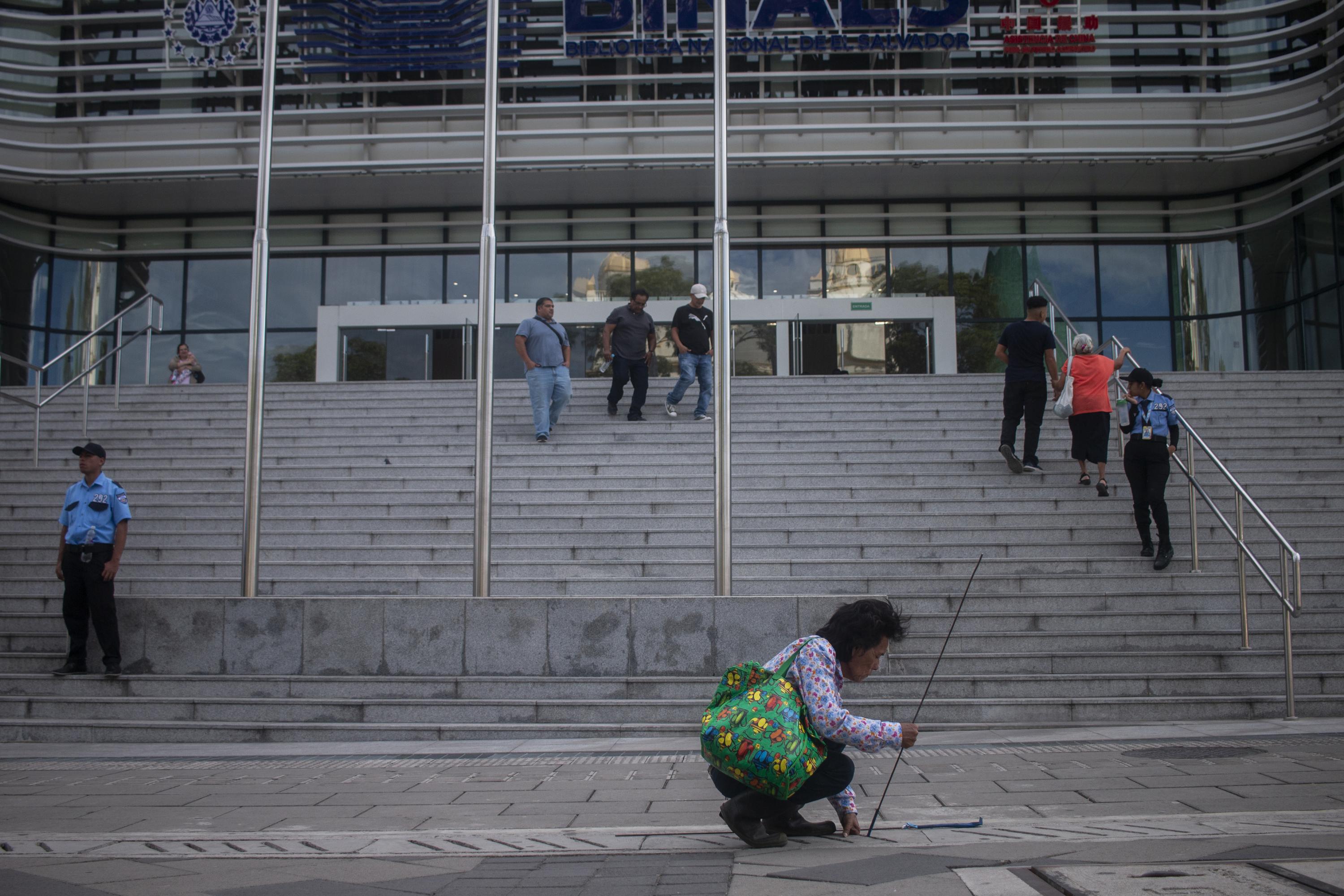 José pepena monedas frente a la Biblioteca Nacional. Camina por las orillas de las calles del Centro Histórico para detectar alguna moneda atrapada bajo las baldosas que cubren los desagües. Tiene 70 años y es un  hacelotodo, 