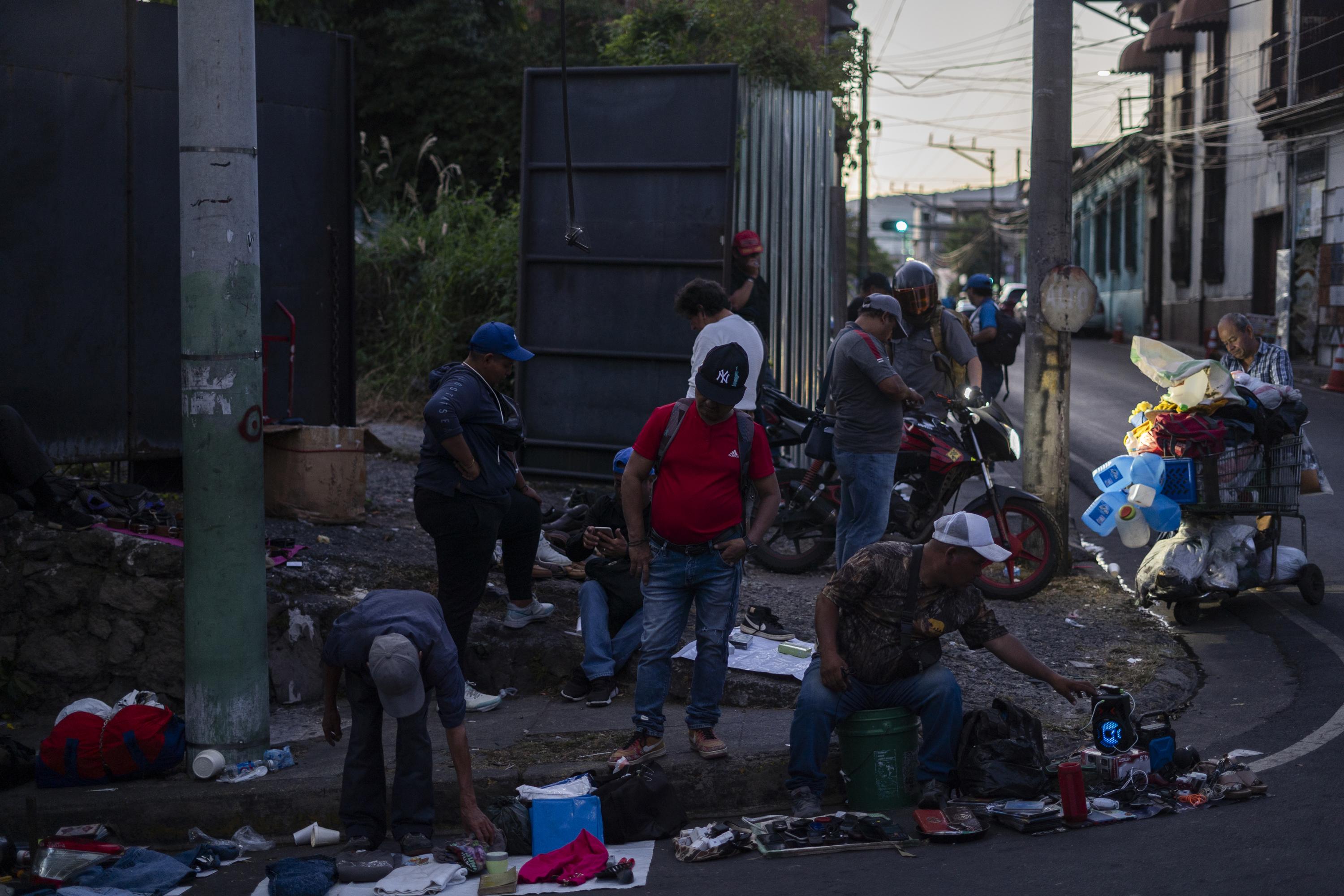 Al final de la tarde, varios vendedores informales coinciden sobre la sexta avenida sur. Es, de momento, una zona segura para hacer trueques, lejos de la constante persecución de los agentes municipales y a sólo tres cuadras de la villa navideña. Un peatón se asoma al grupo de vendedores y muestra su mochila, un par de zapatos, un pantalón, una camisa con la máscara de Spiderman y tres libros viejos. – ¿Cuánto por eso? – pregunta un vendedor. – Lo que usted quiera, maestro – responde. – Tres dólares te doy. – Está bueno. Foto de El Faro: Víctor Peña.