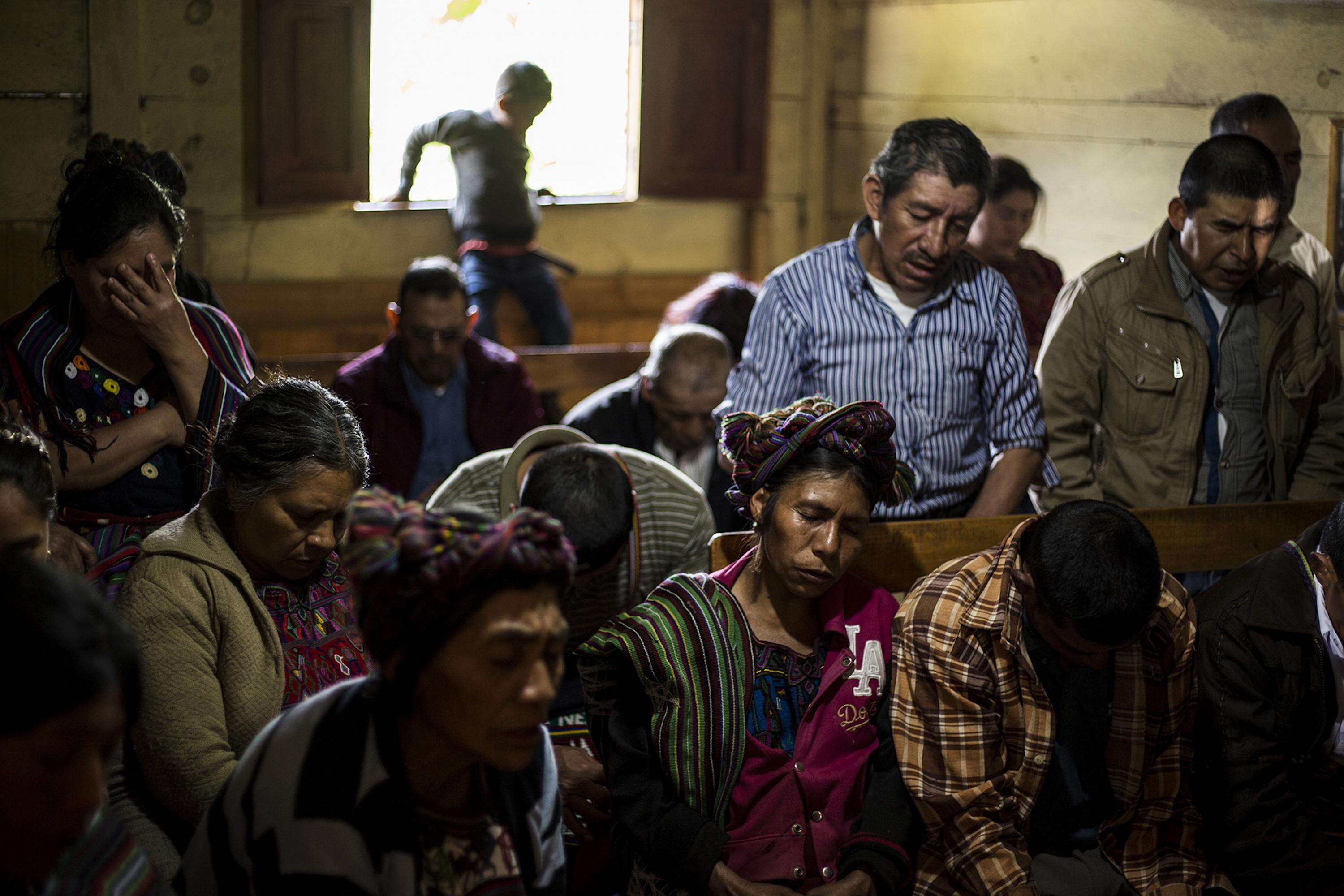 Para iniciar una reunión comunitaria, los habitantes de la aldea Cocop, en Nebaj, oran en lengua ixil. Aquí, escondido entre las montañas y calles polvorientas, se registró una de las primeras masacres en el área ixil durante el conflicto armado guatemalteco: murieron 77 personas el 16 de abril de 1981. Foto de El Faro: Víctor Peña