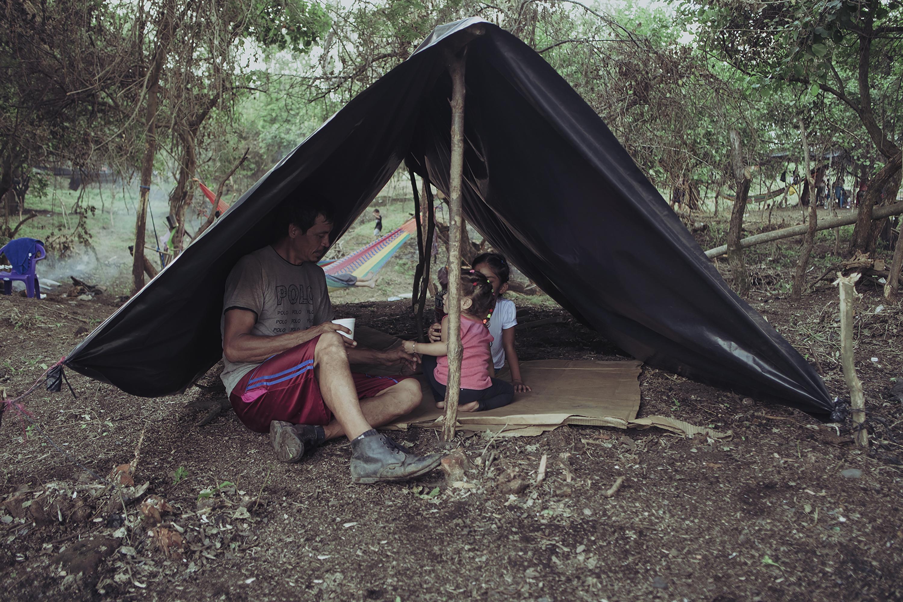 Poverty has increased in recent years in El Salvador, according to the Multi-Purpose Household Survey. In 2023, the poor made up 27.2 percent of the population, an increase of 4.4 percent compared to 2019. In 2020, Sebastián Orellana with his daughters under a tent of sticks and plastic on the land they occupied on the banks of the Grande River in San Miguel. Sebastián was selling basic necessities during the pandemic. Photo Carlos Barrera