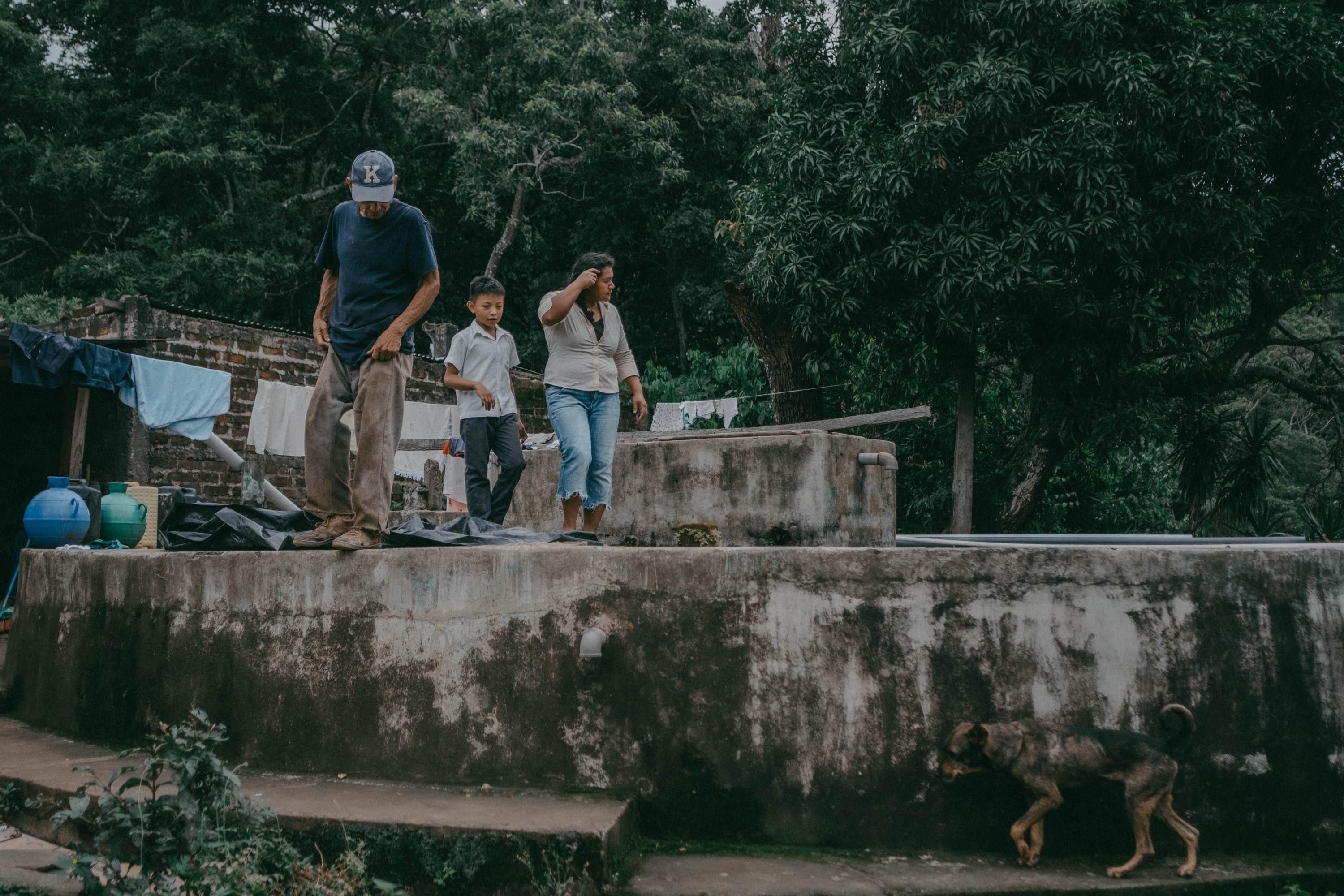 Después de los terremotos de 2001, uno de los tanques de almacenaje de agua en la comunidad El Rescate se dañó y ya no puede sostener agua a su máxima capacidad. Esa agua va desde los tanques y es procesada en la planta que Santos, líder comunitario, opera. Cada semana se pide una colaboración voluntaria para el mantenimiento de la bomba y leves reparaciones que se puedan hacer en los tanques y tuberías. El agua que es purificada sirve para tomar y cocinar; para el resto de actividades, las familias deben viajar hasta el nacimiento de agua conocido como El Río y acarrear agua.