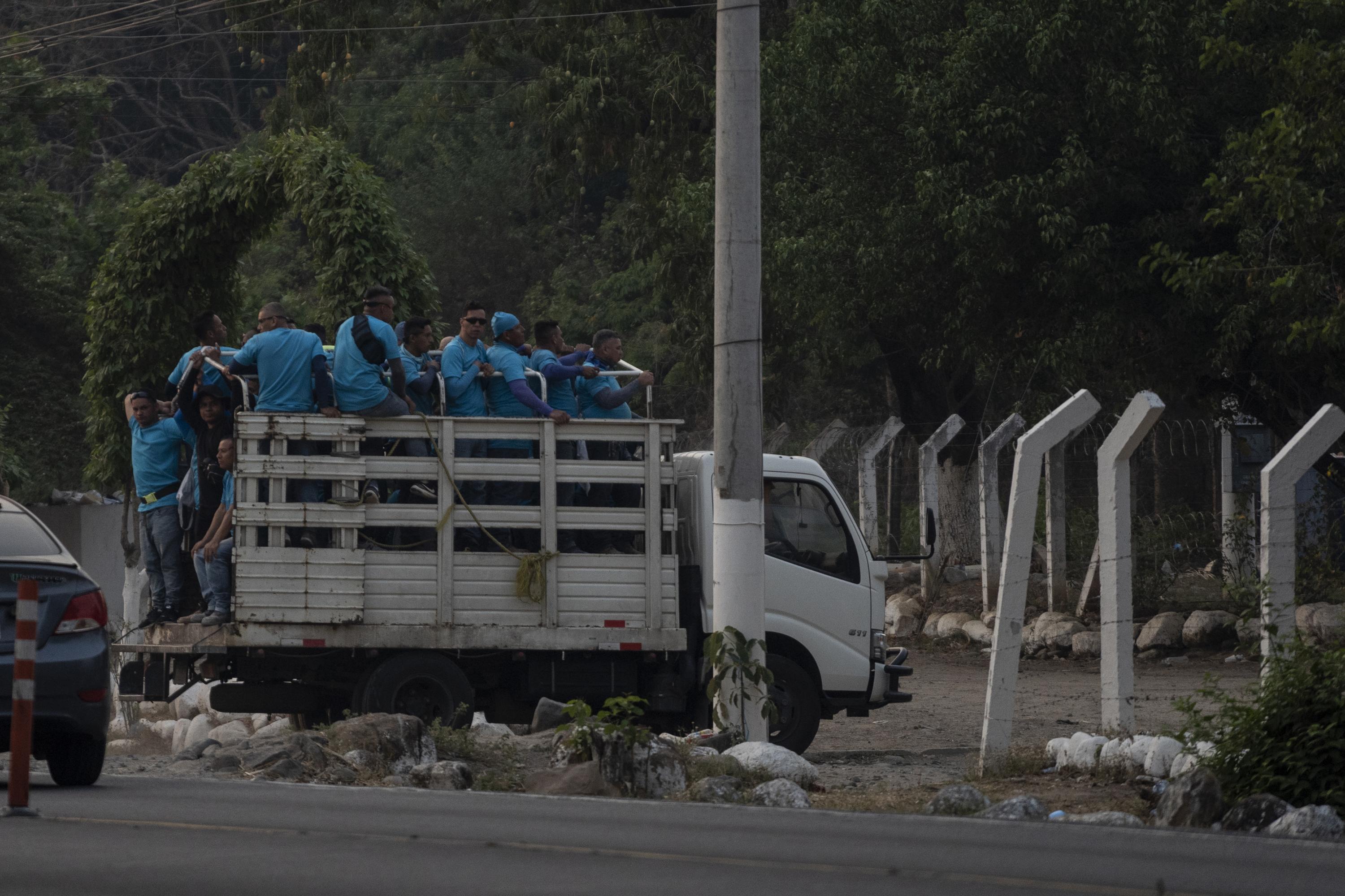 Reos de fase de confianza ingresan al Centro de Detención Menor de Zacatecoluca, en el departamento de la Paz, el jueves 13 de abril de 2023, al final de una jornada de trabajo de construcción de una casa en la playa Las Hojas. Foto de El Faro: Víctor Peña. 