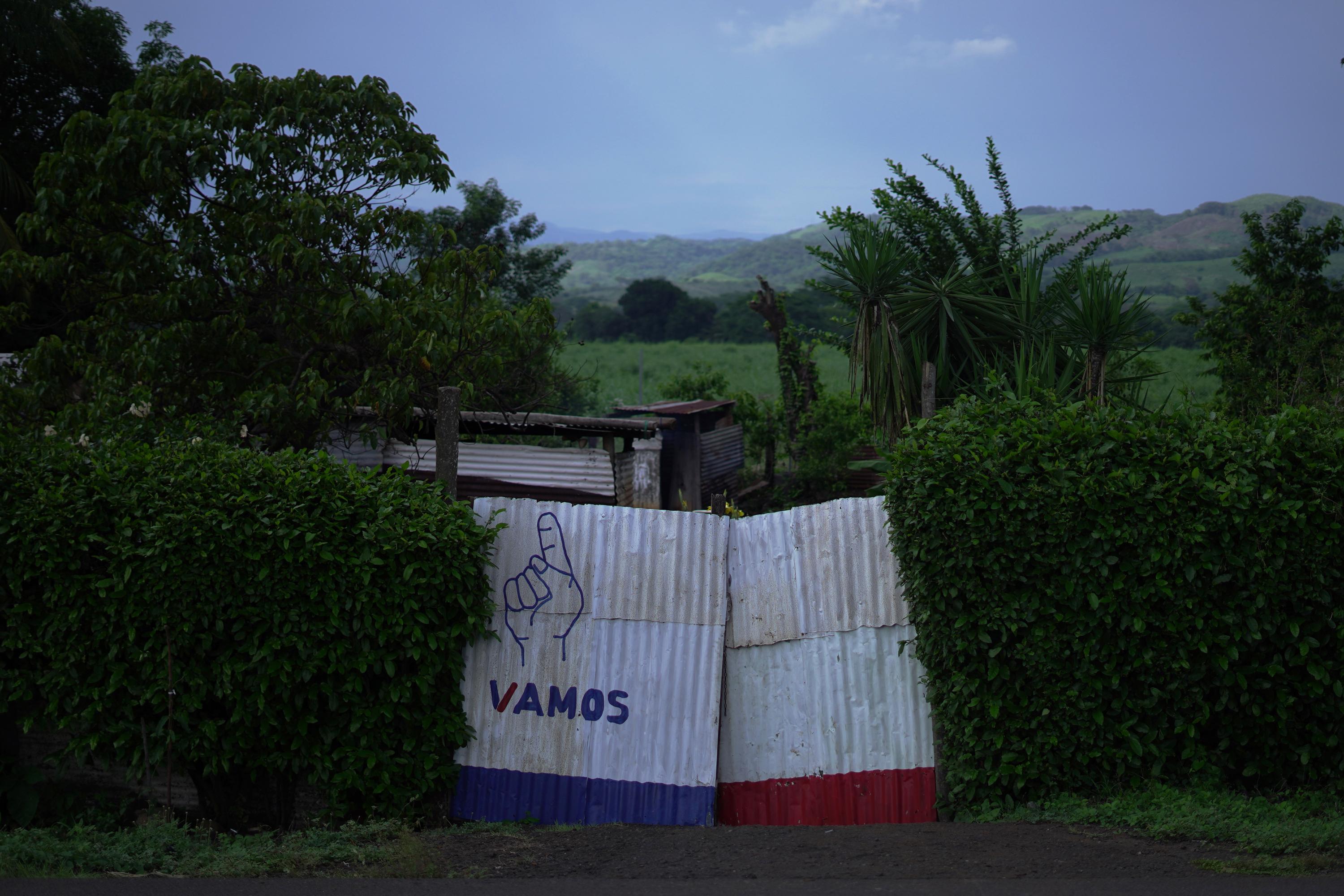 In the run-up to the 2023 national elections in Guatemala, ampaign ads for the ruling party Vamos coat the gate to a home in the village of Cinco Palos, Gunagazapa, in the department of Escuintla.