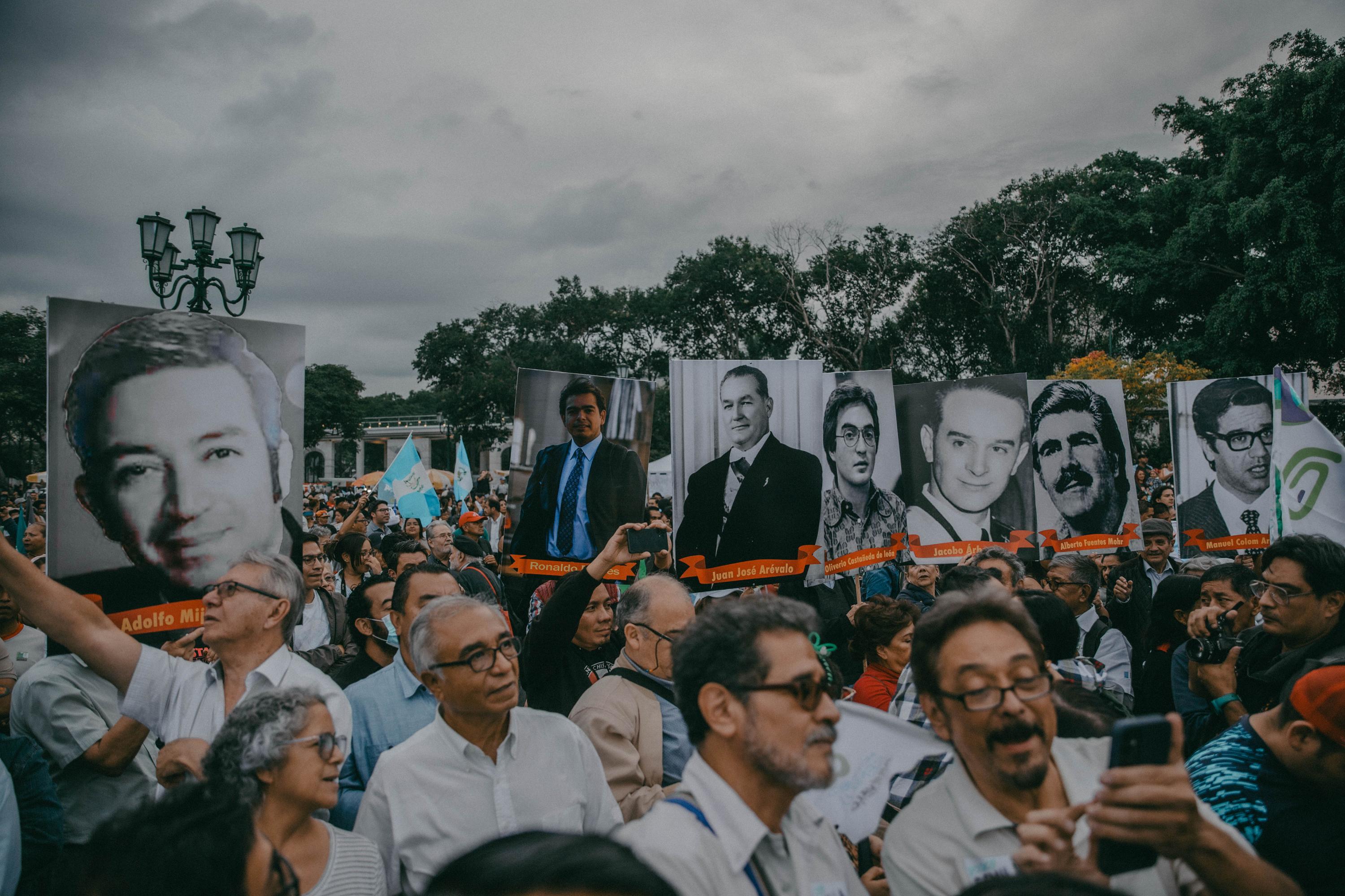 Durante el mitin de Semilla, los asistentes llevaron imágenes de líderes históricos de la izquierda en Guatemala, entre ellas estaba la fotografía del líder estudiantil Oliverio Castañeda de León, asesinado en octubre de 1978. También portaron la fotografía de Ronaldo Robles, quien fue jefe de campaña de Semilla para las elecciones presidenciales y falleció durante un accidente en febrero del 2023. Foto de El Faro: Carlos Barrera