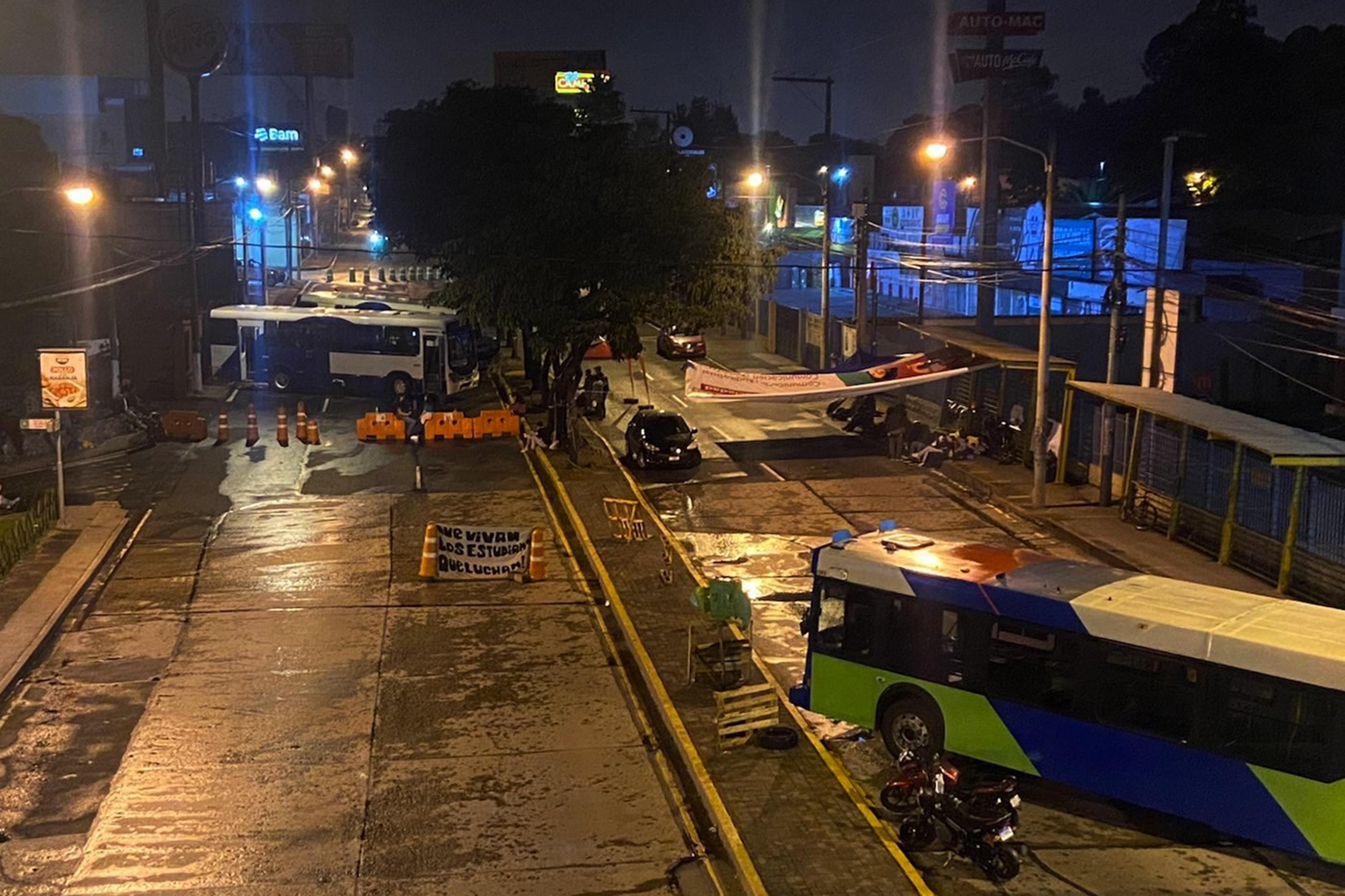 Este viernes 6 de octubre, una docena de estudiantes y egresados de la San Carlos cortó el paso a tres buses sobre la Avenida Petapa en Zona 12 de Ciudad de Guatemala, frente a una entrada a la universidad. Los buses se estacionaron en diagonales para bloquear el tráfico. Foto de El Faro: Roman Gressier