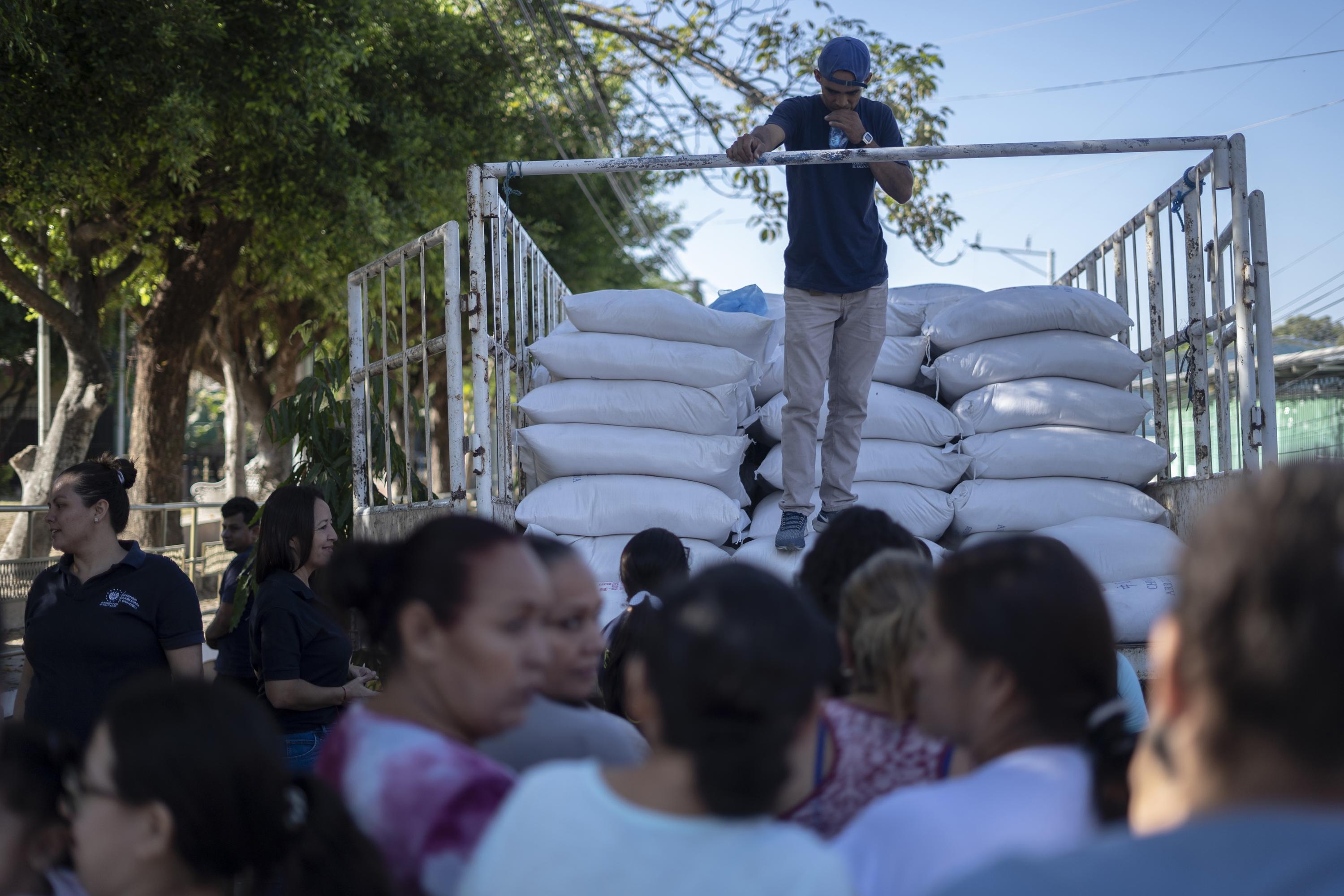 Employees from the Ministry of Agriculture and Livestock hand out bags of rice to residents of San Rafael, Chalatenango, on Wednesday, Jan. 24, 2024. Photo Víctor Peña