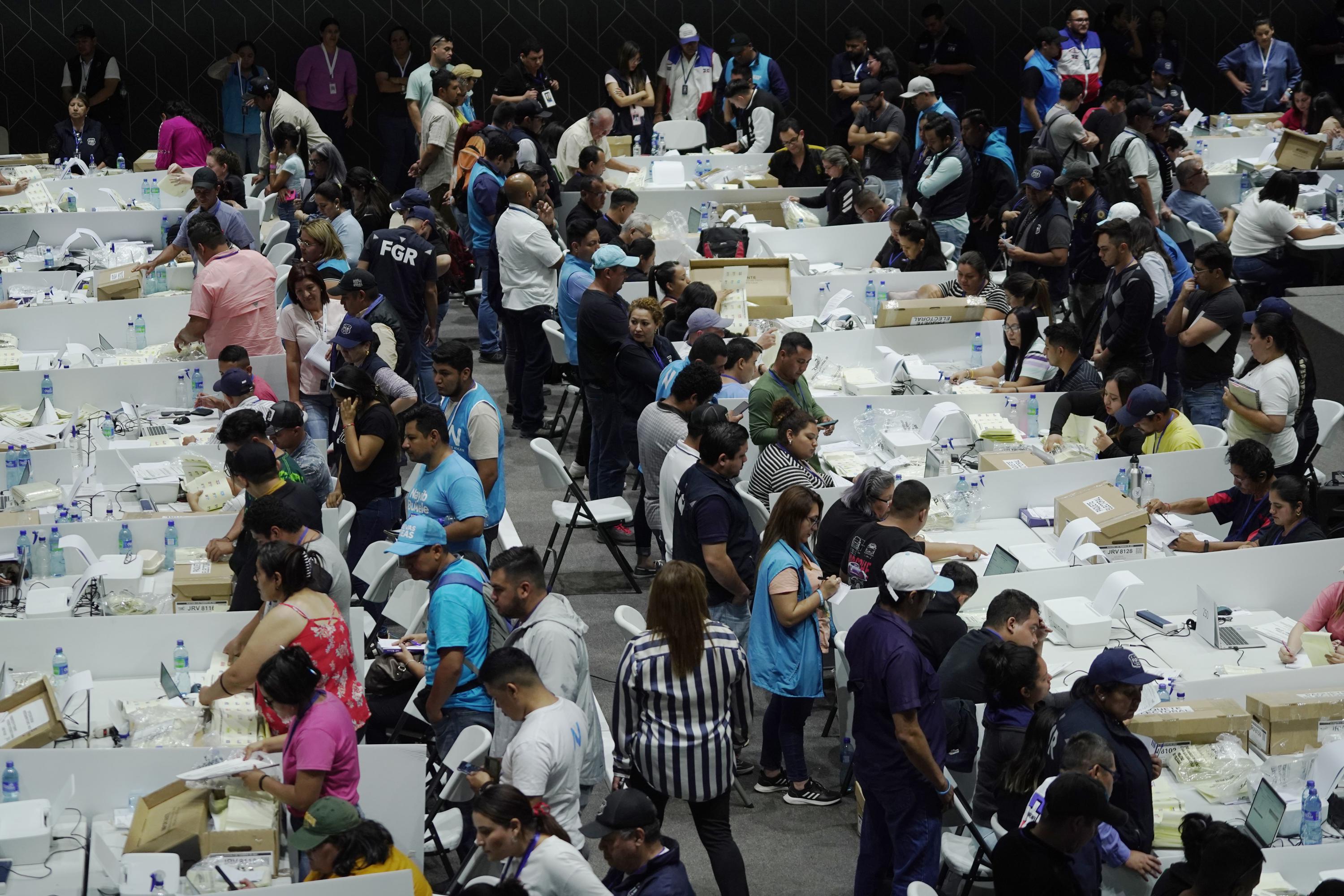 El conteo de votos inició a las 5:00 de la tarde del domingo 11 de febrero, en el gimnasio Adolfo Pineneda, de San Salvador. En las mesas había presencia mayoritaria de vigilantes afines al partido Nuevas Ideas, y también funcionarios del Gobierno que dirigieron la operación. Foto de El Faro: Víctor Peña.