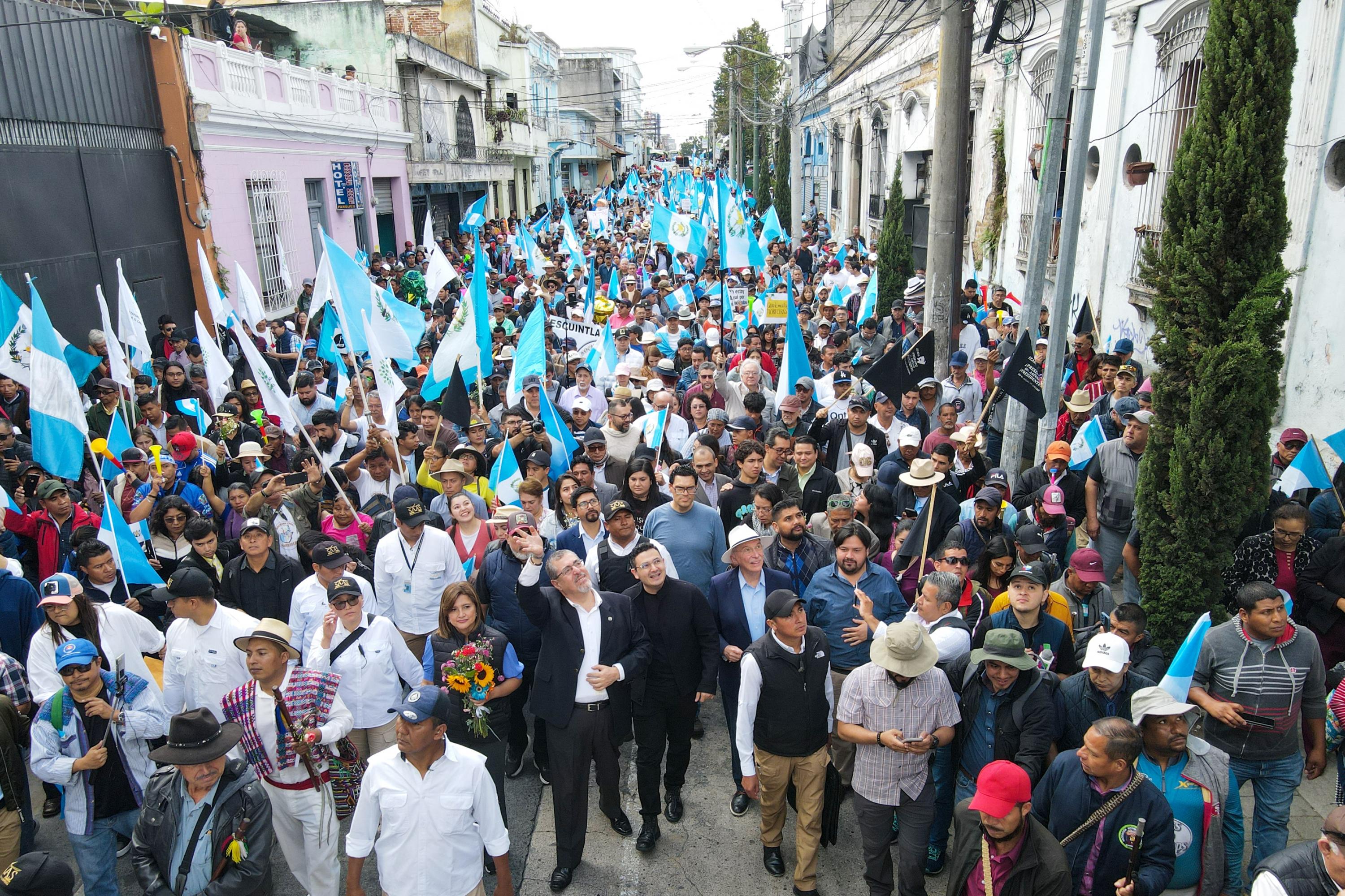 Guatemalan President-elect Bernardo Arevalo waves to supporters alongside Semilla legislator Samuel Pérez while taking part in the “March for Democracy” to demand the resignation of Attorney General Consuelo Porras and prosecutor Rafael Curruchiche, actors working to overturn the election results, in Guatemala City on December 7, 2023. Photo Carlos Alonzo/AFP