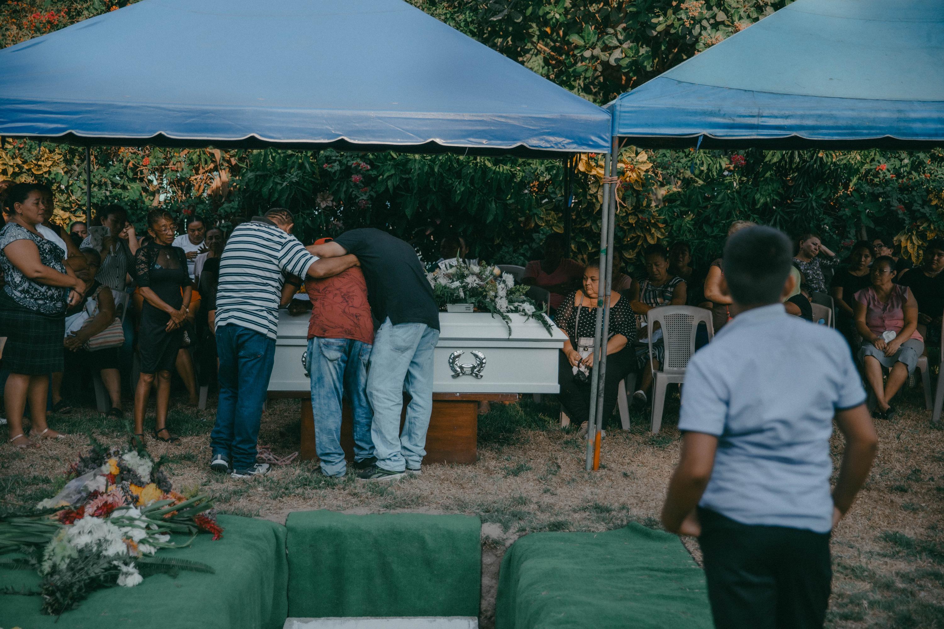 Familiares de Rodrigo Vásquez, de 44 años, lloran sobre su ataúd el 13 de marzo del 2023 en un cementerio privado de San Luis La Herradura. Rodrigo fue detenido el 9 de mayo de 2022 bajo el régimen de excepción de El Salvador y murió en la cárcel de Izalco. Foto de El Faro: Carlos Barrera.