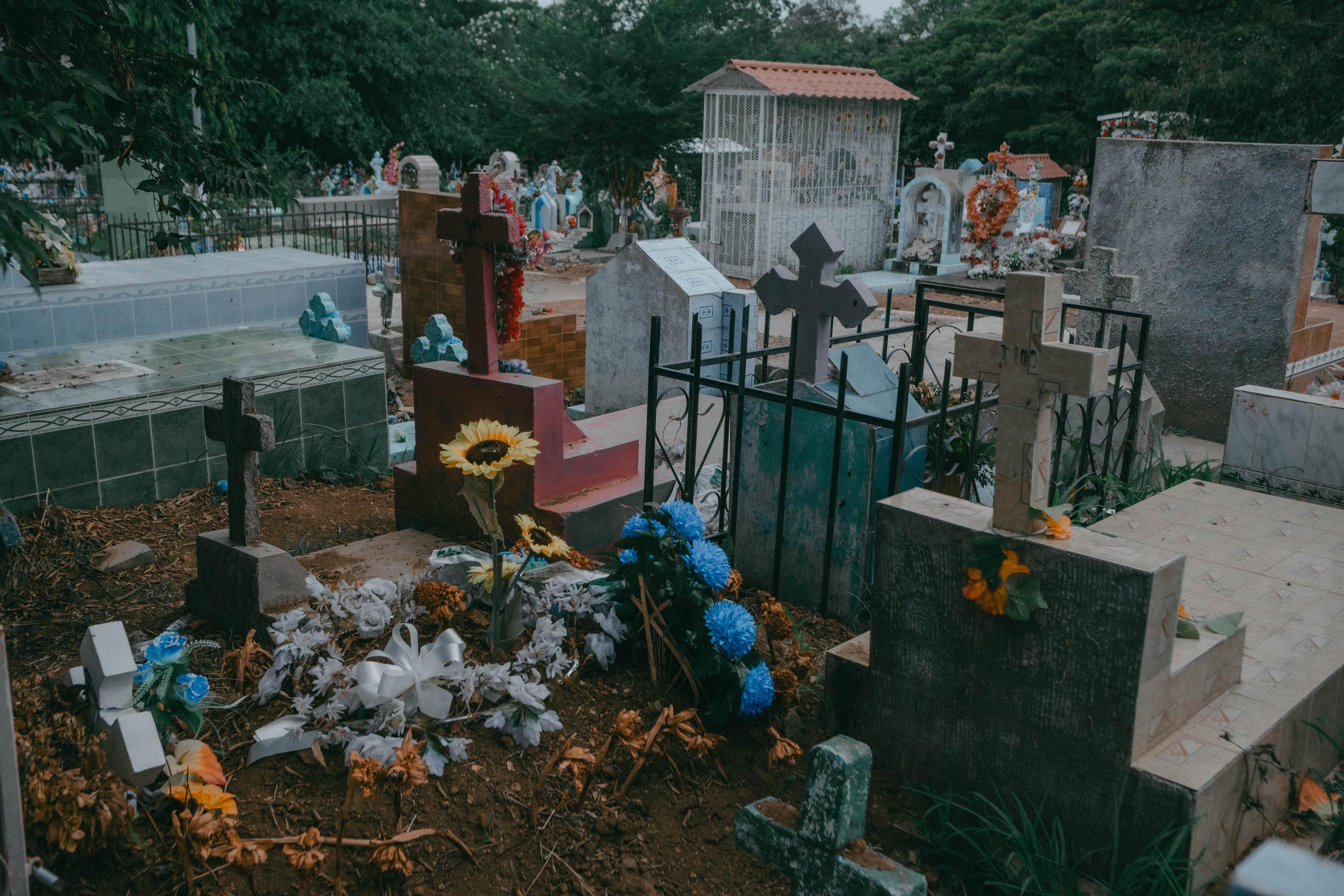 Carlos died while in state custody after being captured during the state of emergency. His space doesn’t have a cement structure; a sunflower grows on the surface among some mementos left by family and friends. Photo Carlos Barrera