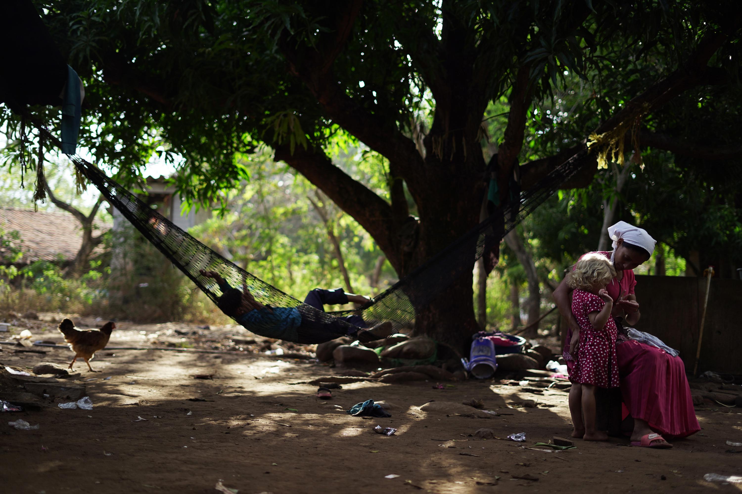 La mujer del vestido rojo tiene 24 años y es madre de cinco hijos, el mayor tiene 10. La comunidad de La Criba está compuesta de personas pobres que tendrían problemas en reubicarse en el agitado mercado inmobiliario de La Unión. Foto: Víctor Peña