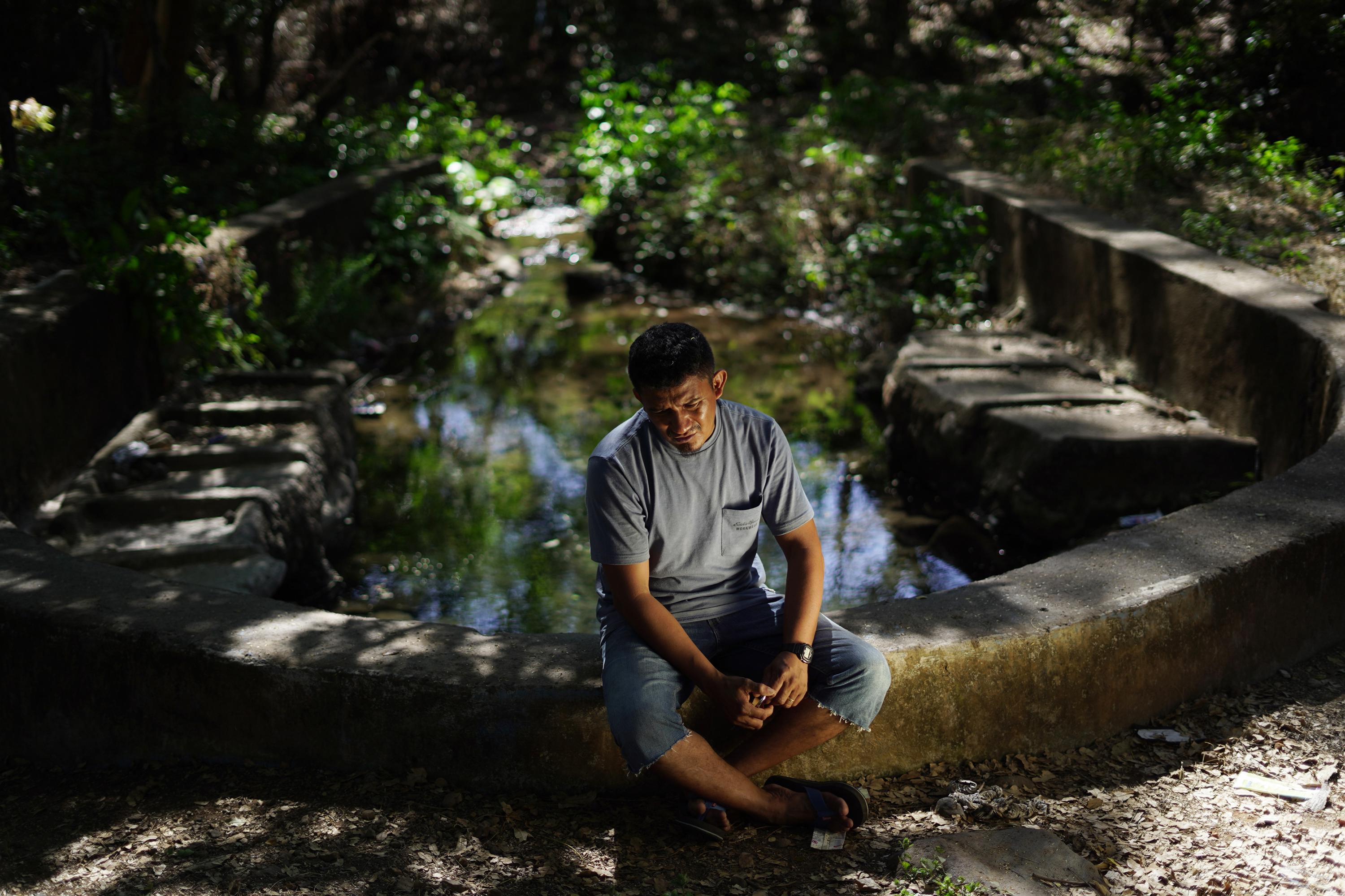 Will Claros said his relatives who live in the U.S. like to come and hang out at this pond, where the Condadillo community collects water for daily use. The Pacific Airport project will wipe it out and trees around it have been marked for removal. Photo Víctor Peña