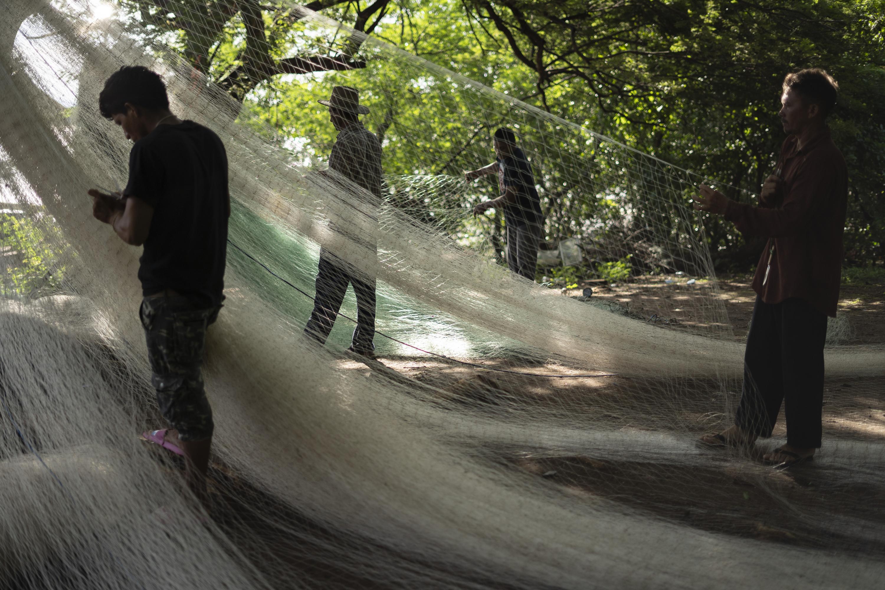 Fishing is the only option to make a living for most of the men living in areas surrounding the construction of the new airport. In this image, employees repair the net of a wholesale merchant in El Embarcadero, a village in the municipality of Conchagua, La Unión. Photo Víctor Peña