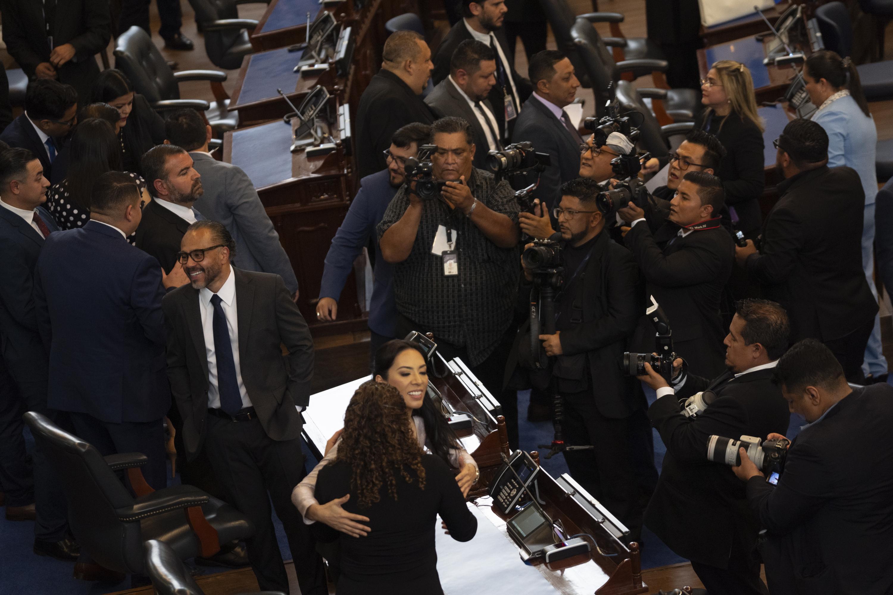 Ernesto Castro y Suecy Callejas, diputados oficialistas, son retratados por empleados de la Asamblea Legislativa, durante la toma de posesión del nuevo periodo legislativo, el 1 de mayo de 2024. Uno de los requisitos que pide el FMI para aprobar el financiamiento a El Salvador es el recorte del personal en instituciones públicas. Foto de El Faro: Víctor Peña. 