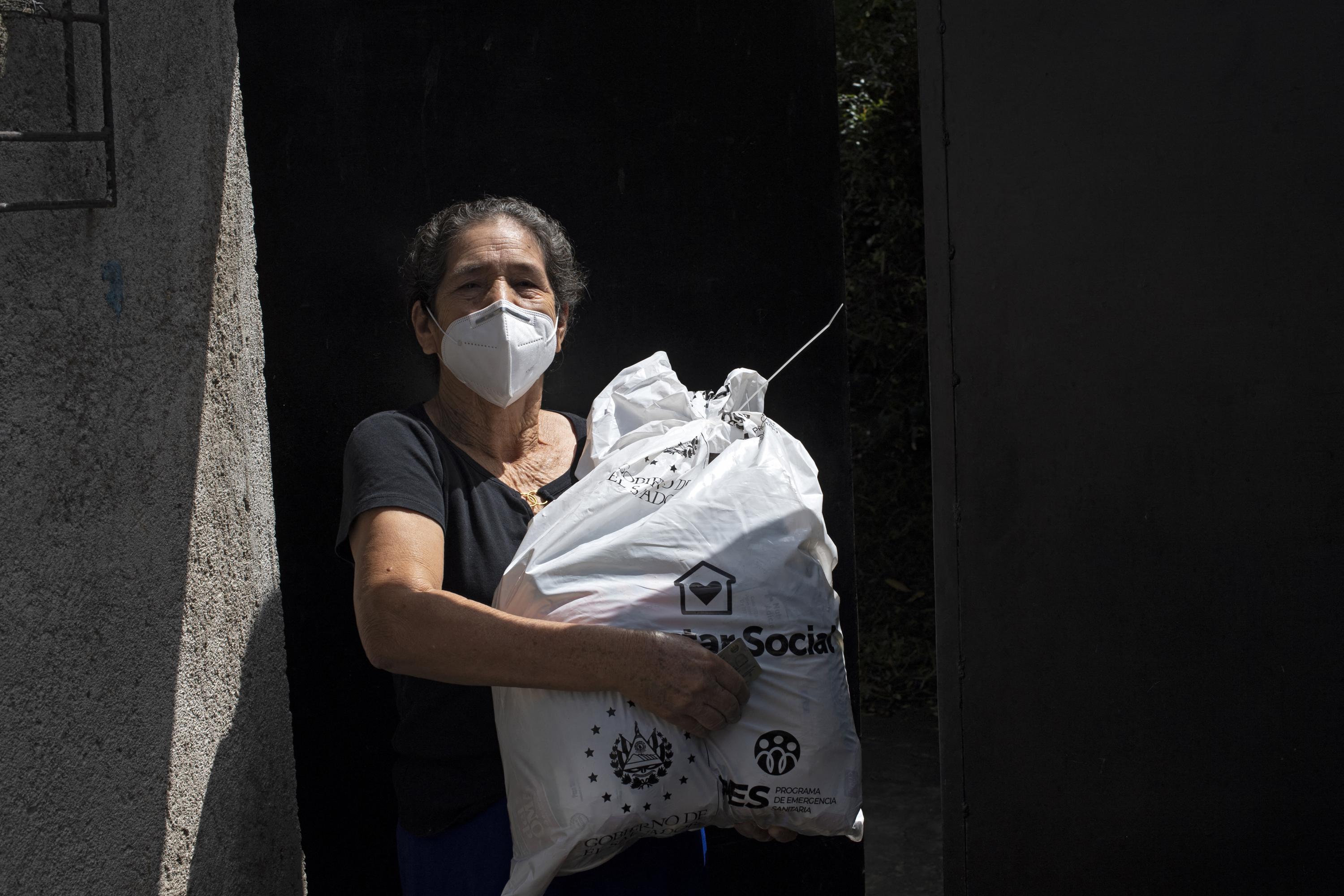 A woman receives a bag of food from the Salvadoran government