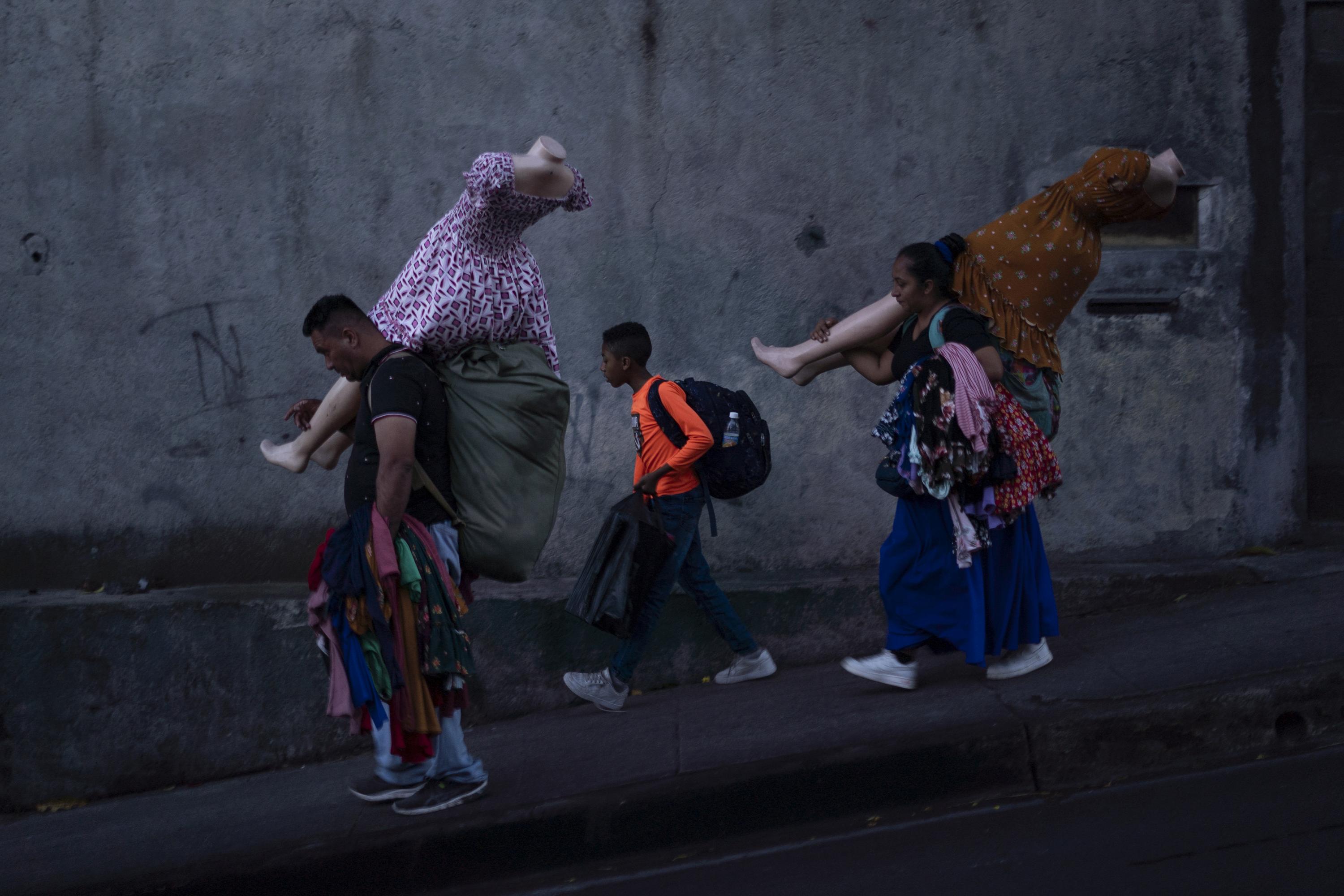 A family of vendors walks toward Plaza Zurita, on Eighth Street East, in downtown San Salvador. In the same area converge other vendors who are also fleeing from the metropolitan police (CAM), who maintain permanent operations to displace and confiscate products from informal traders who approach the revitalized blocks of the Historic Center. Among many conversations with vendors, a few phrases stand out: “Those government people have gone crazy with money.” “All of them will have a bad end.” “They don’t go hungry, they have all they need.” “Either they get tired or we get tired.” Photo Víctor Peña