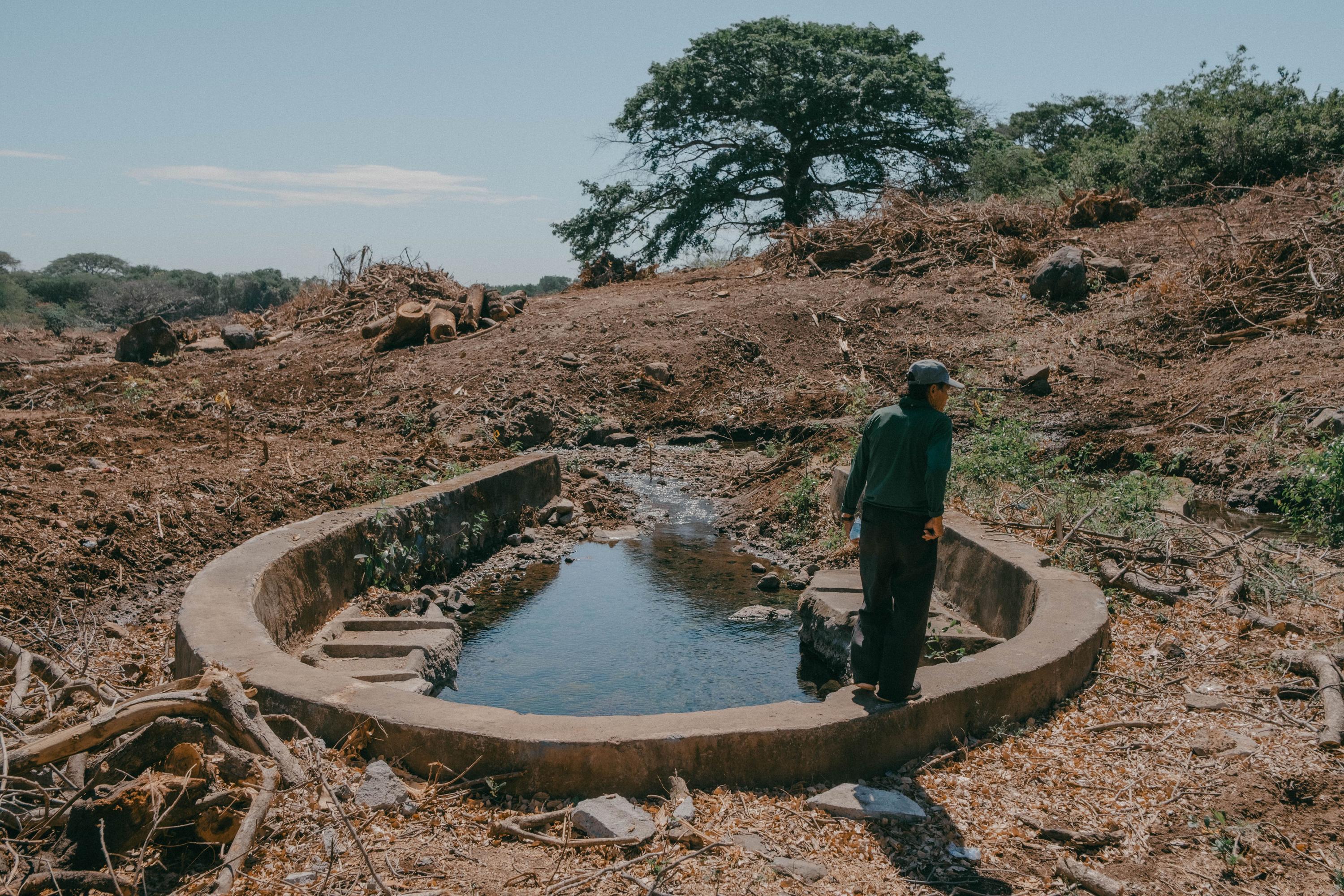 José Candelario Gavidia tiene 63 años y, según dice, desde antes de que él naciera los lavaderos ya había sido construidos. A ese lugar llegaba toda la gente de cantones aledaños en caballos para abastecerse de agua y lavar. Estaba rodeado por una colina y árboles que ahora ya no existen. Desde que se iniciaron las labores de terracería, en diciembre del 2024, nadie llega al nacimiento de agua a lavar, por temor a los trabajadores de CEPA que constantemente vigilan el sitio y cuestiona la presencia de pobladores.