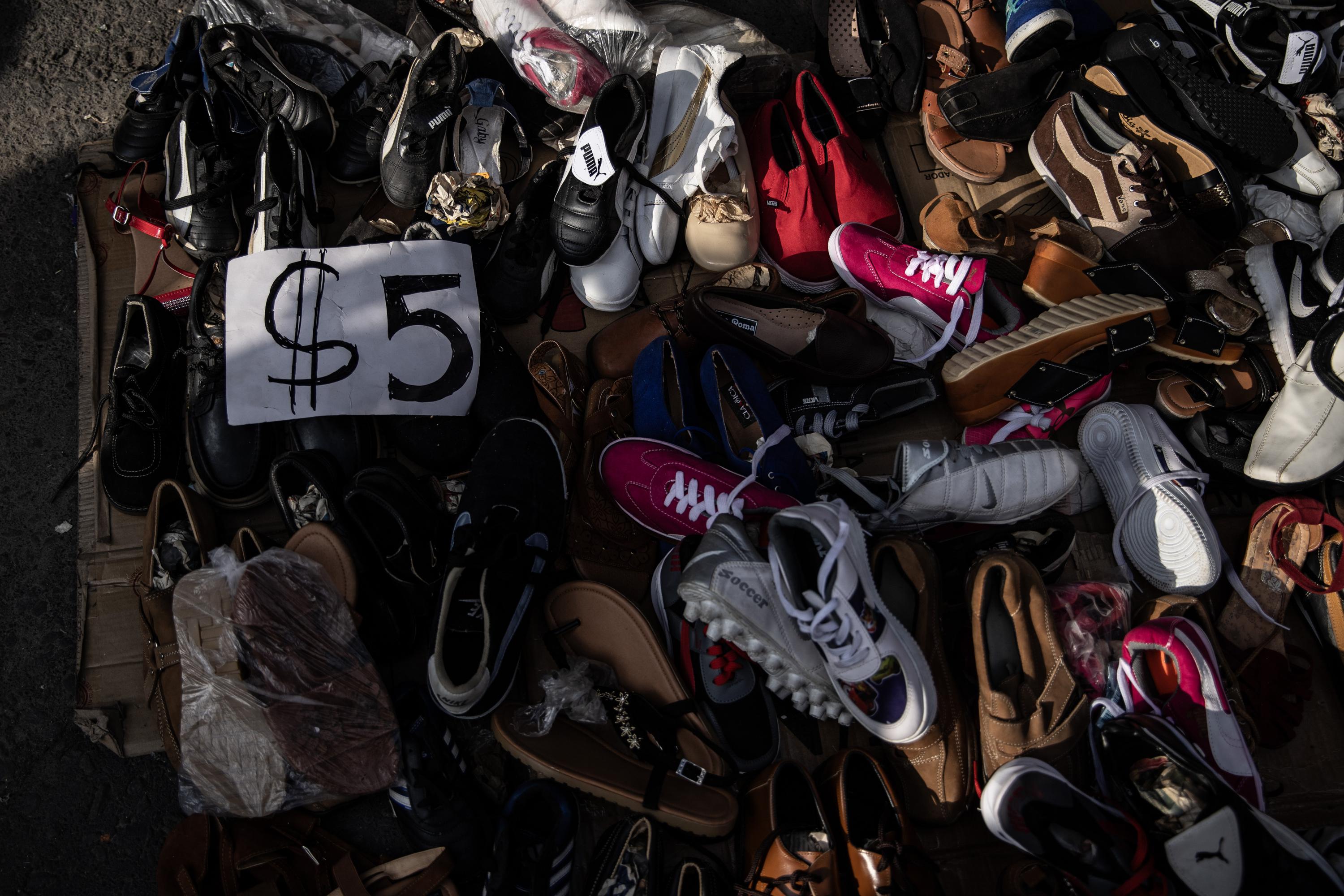 Fearing that they would be left sitting on their investment, many vendors pulled out their products into the middle of the street for sale. This stand began selling all shoes for $5 dollars each, regardless of whether they were for chiildren or adults. Photo Carlos Barrera