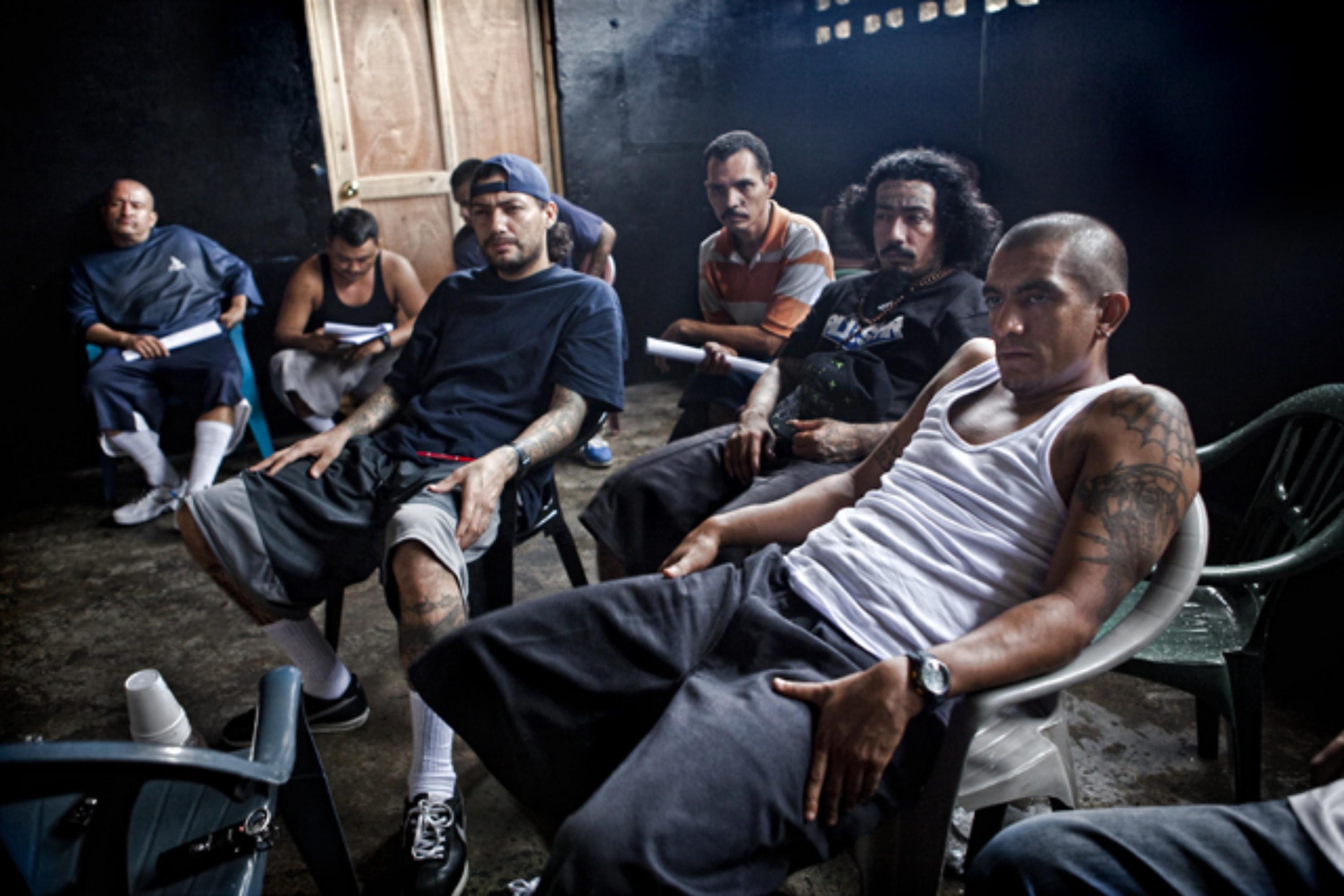 The Ranfla Nacional of the Mara Salvatrucha during one of the interviews they granted to El Faro in 2012. At the back of the group, Chino listens into the conversation before interrupting. Photo Pau Coll