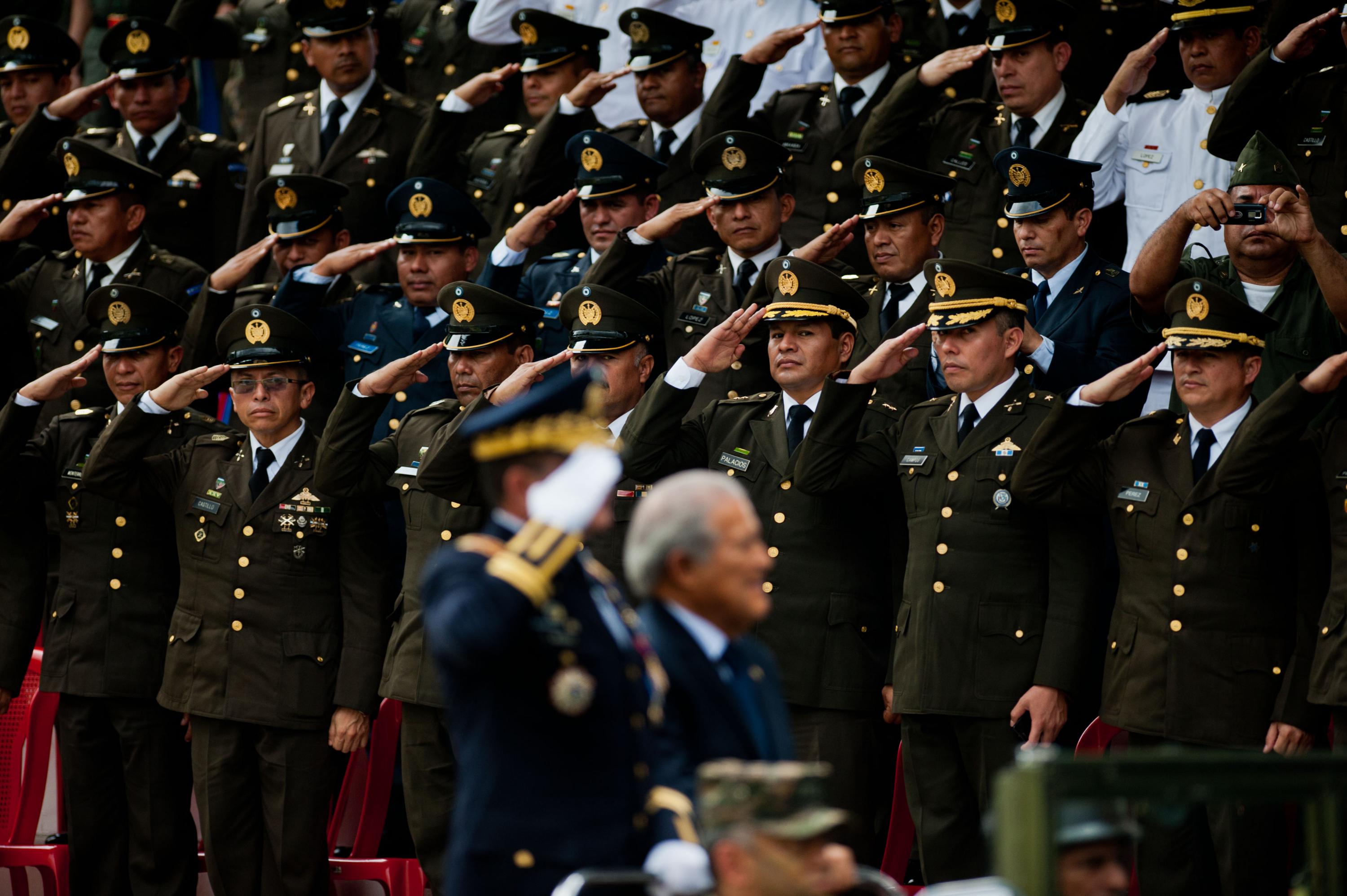 Oficiales salvadoreños saludan al presidente Salvador Sánchez Cerén y al ministro de Defensa, David Munguía Payés, durante la ceremonia en la que Sánchez Cerén, un excomandante de la guerrilla, asumió la comandancia general de las fuerzas armadas salvadoreñas.  5 de junio de 2014. AFP PHOTO/ José Cabezas