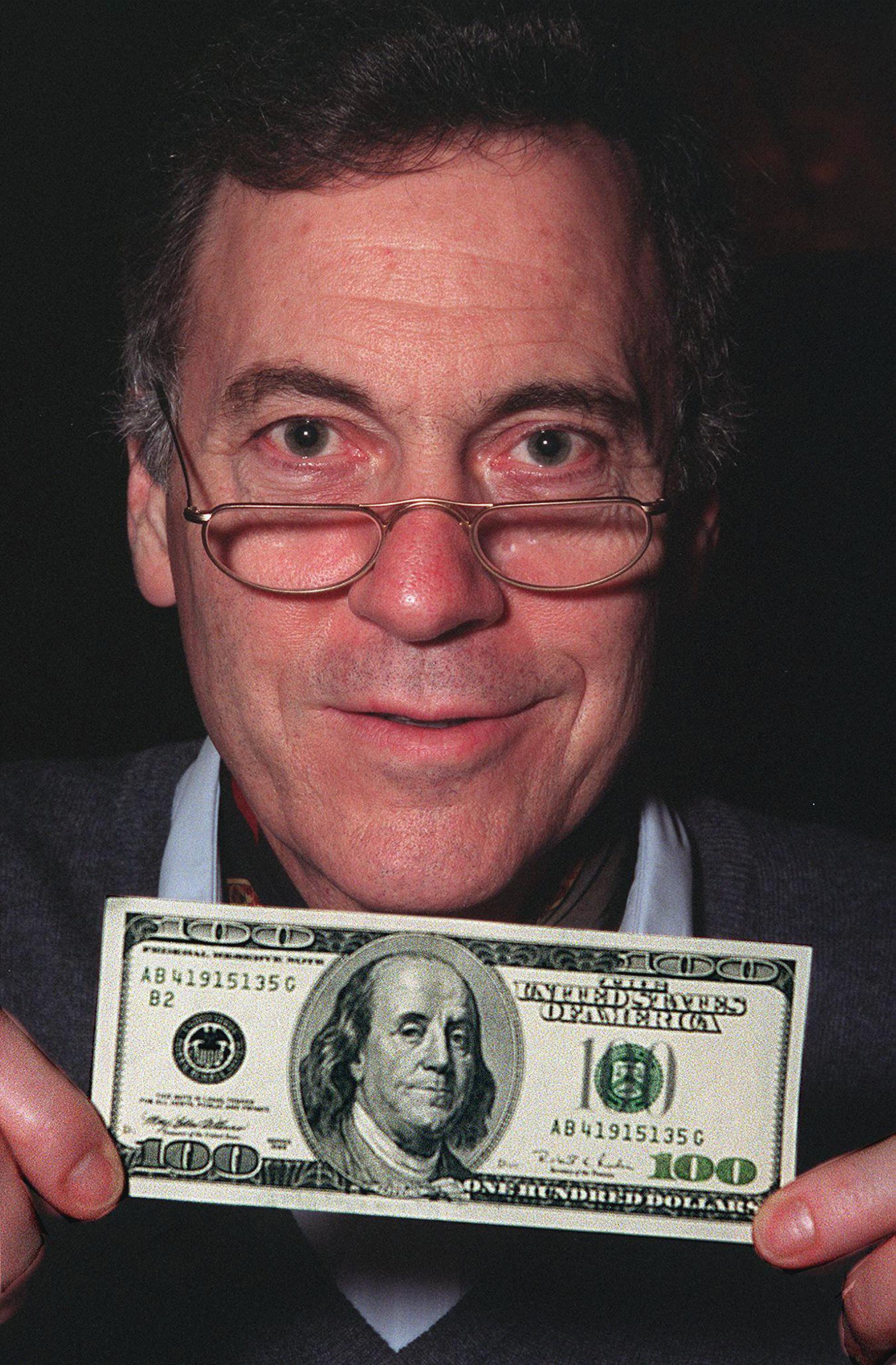 El  economista estadounidense Steve Hanke posa con un billete de 100 dólares el 27 de marzo de 1998 en Hong Kong. Hanke ha sido por décadas un promotor de la dolarización y sistemas monetatrios anclados a la moneda estadounidense. Foto de El Faro: Robyn Beck/ AFP.