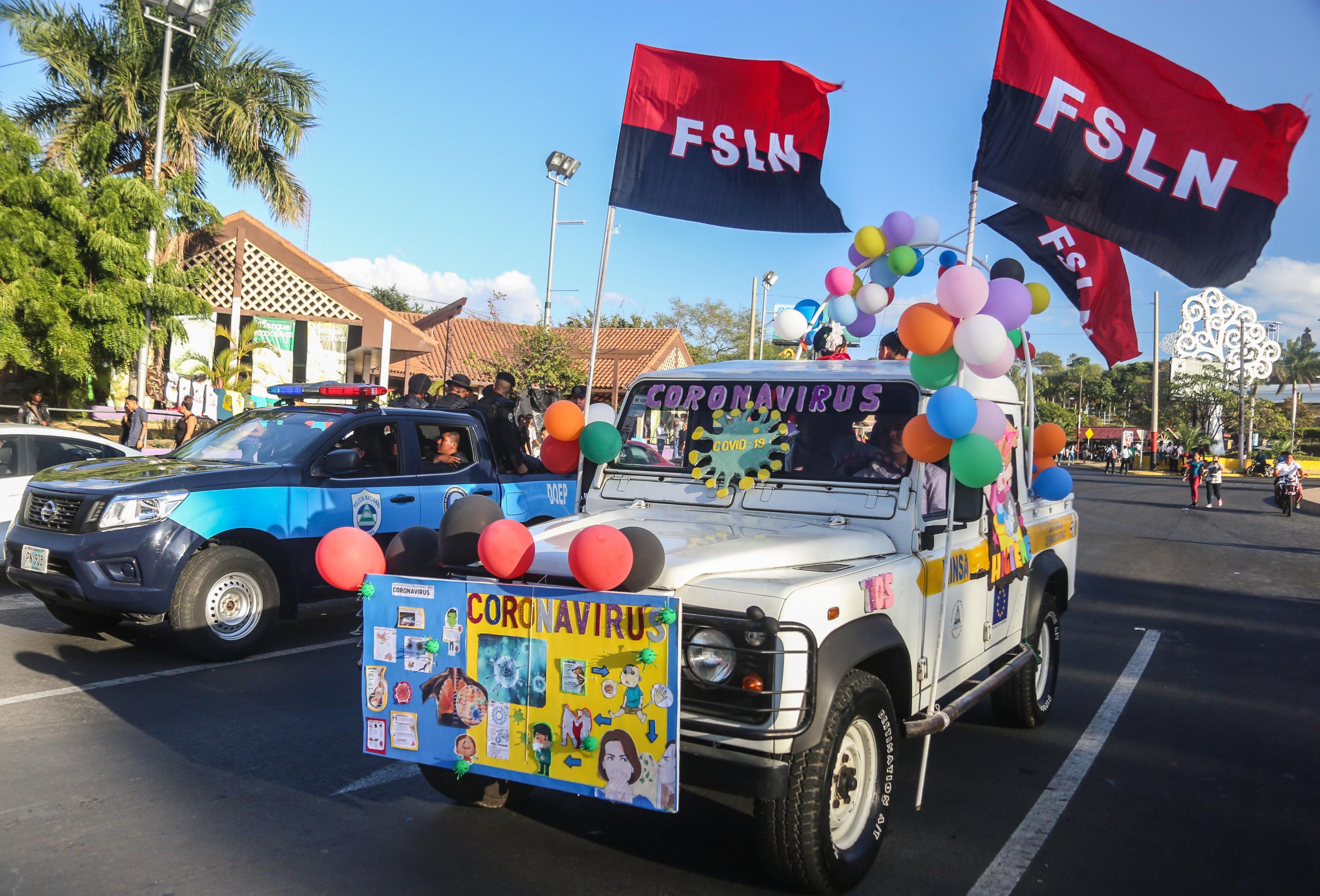 A car touting an anti-coronavirus message paired with sandinista flags participates in Nicaragua